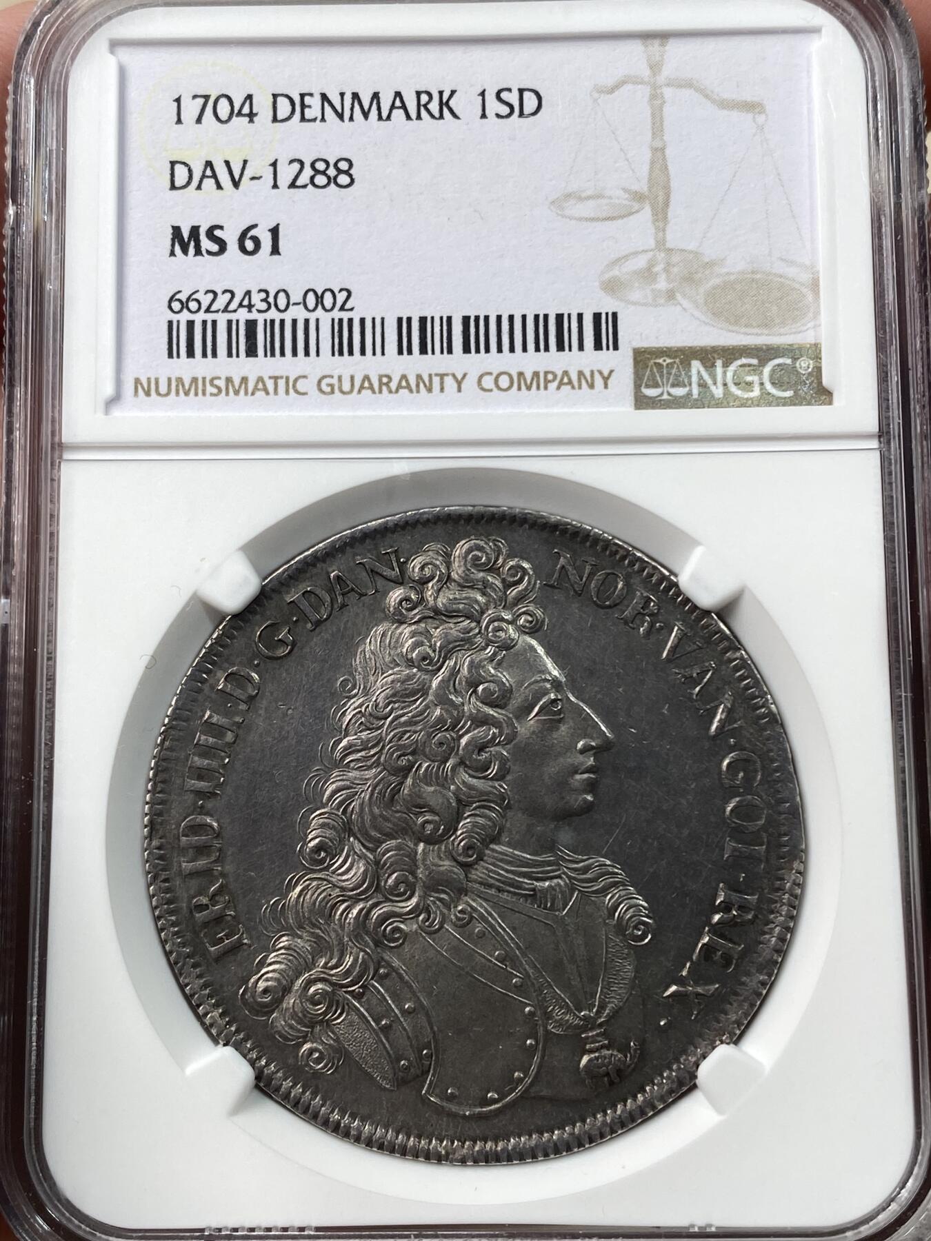 万国钱币拍卖第034期 NGC MS61 1704年丹麦弗雷德里克四世塔勒大银 极其稀有的品种，哥本哈根铸币厂造，铸造量仅309枚，双面一色老包浆，打制极佳，性感波浪卷发一览无余，斯堪的纳维亚系列藏家不可或缺的进阶品种。