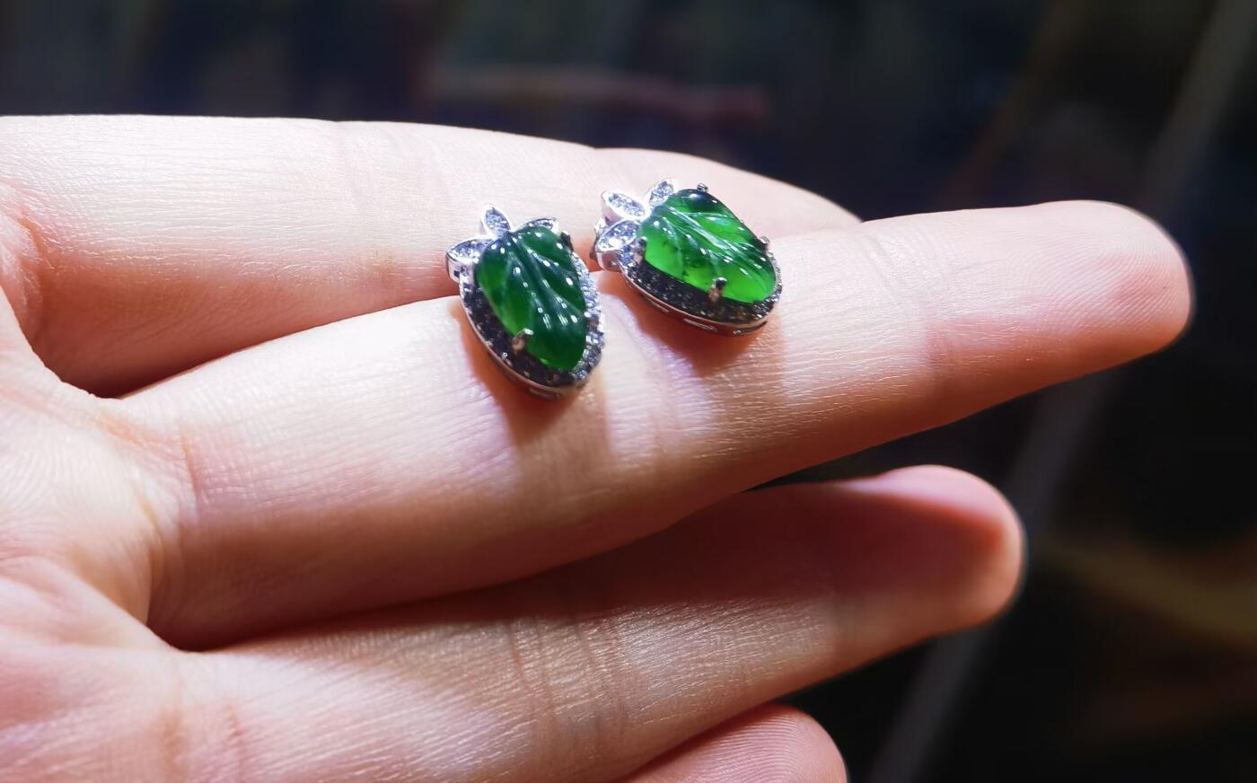 翡翠耳钉一叶生财燕京啤酒瓶底绿，水润冰透，色泽饱满浓郁，纯银镶嵌，可代镶金，性价比超高！裸石尺寸:10mm*7mm   图片拍摄为室外自然光线跟室内灯光下。