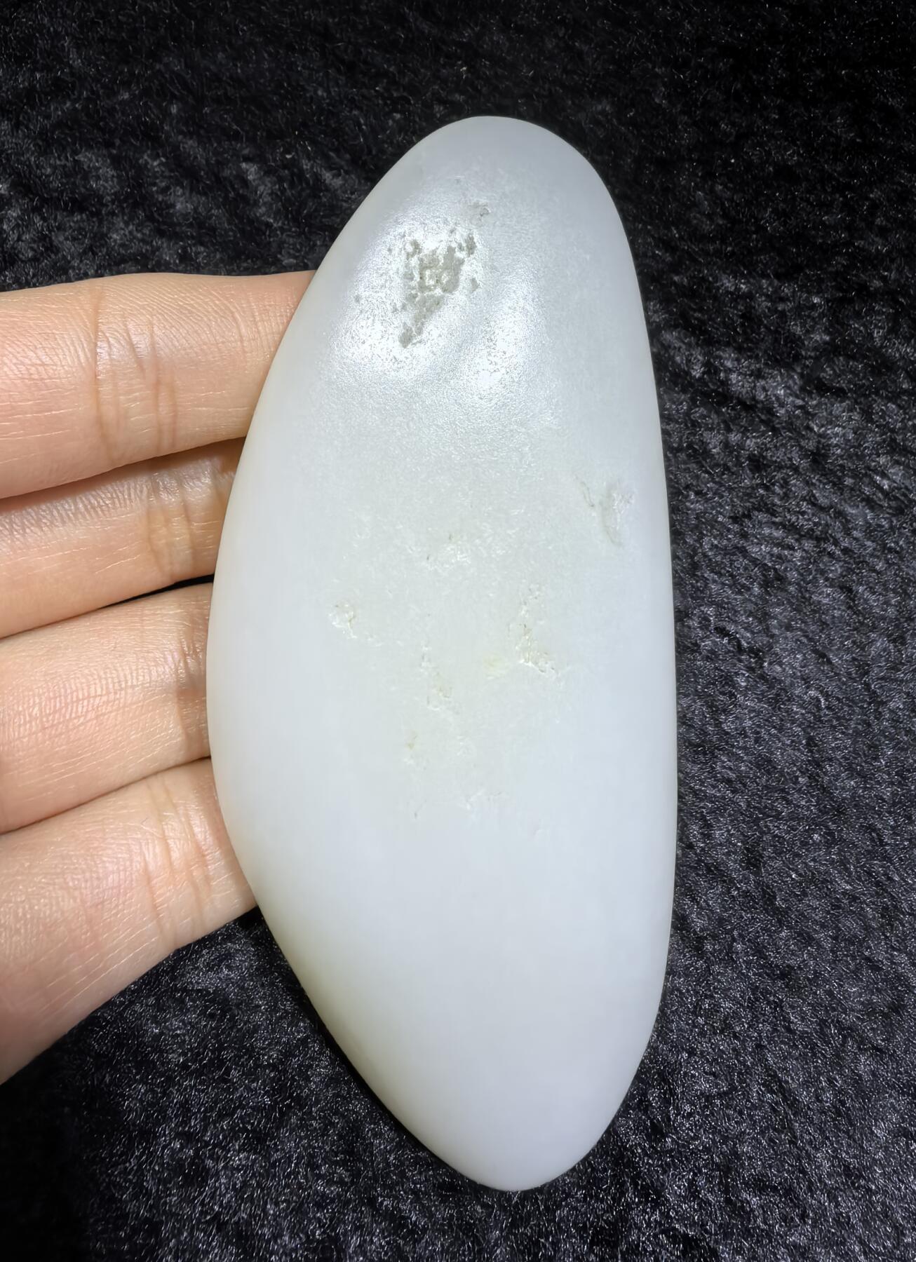 和田籽料一级白手把件 ​玉质温润细腻光滑，手感油润，表皮可见天然毛孔撞击坑，未打孔！