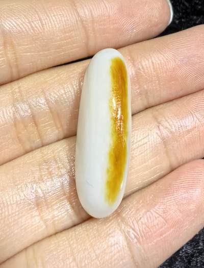 和田籽料撒金皮羊脂白玉吊坠挂件，玉质油润细腻打灯无结构，未打孔可代镶，表皮可见天然毛孔！尺寸:2.9*1.2*0.8cm   克重:5.7g ​ 和田籽料撒金皮羊脂白玉吊坠挂件，玉质油润细腻打灯无结构，未打孔可代镶，表皮可见天然毛孔！尺寸:2.9*1.2*0.8cm   克重:5.7g ​