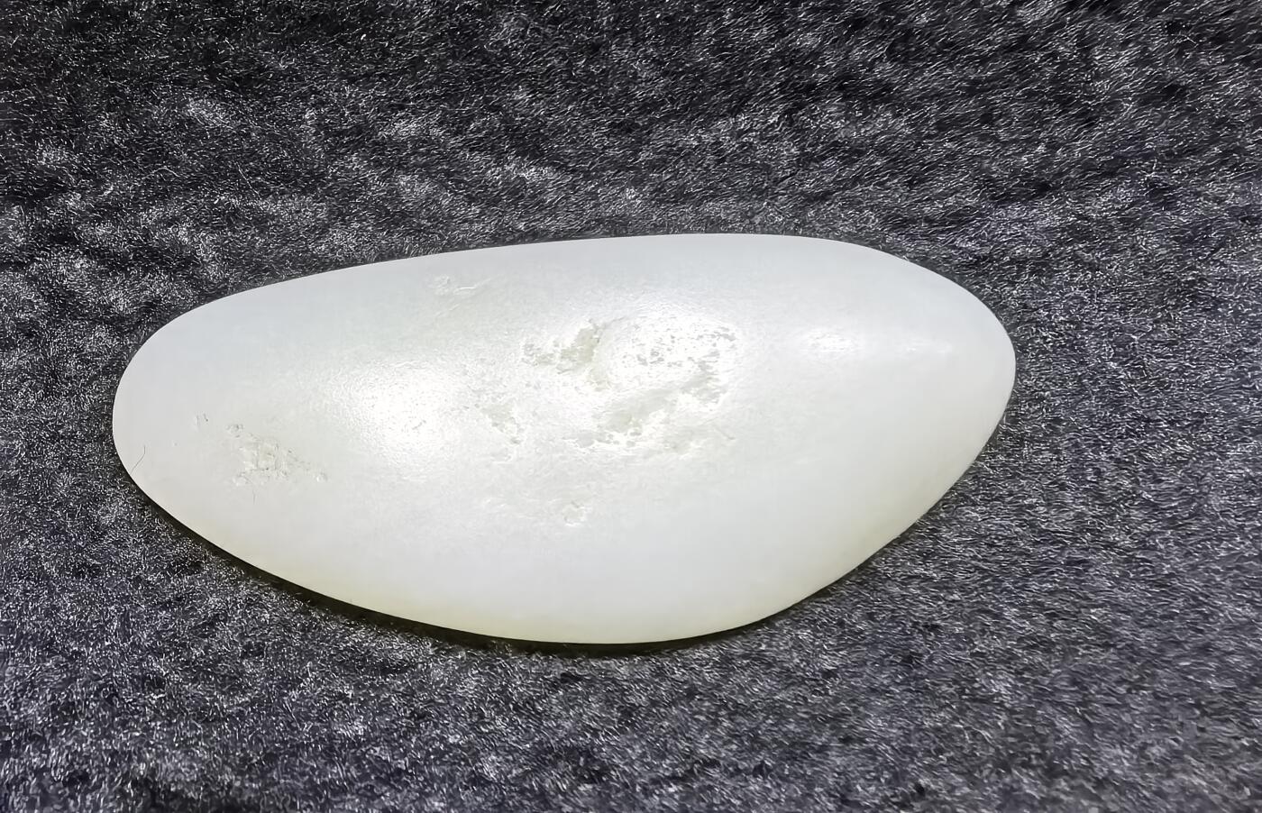 和田籽料一级白手把件 ​玉质温润细腻光滑，手感油润，表皮可见天然毛孔撞击坑，未打孔！