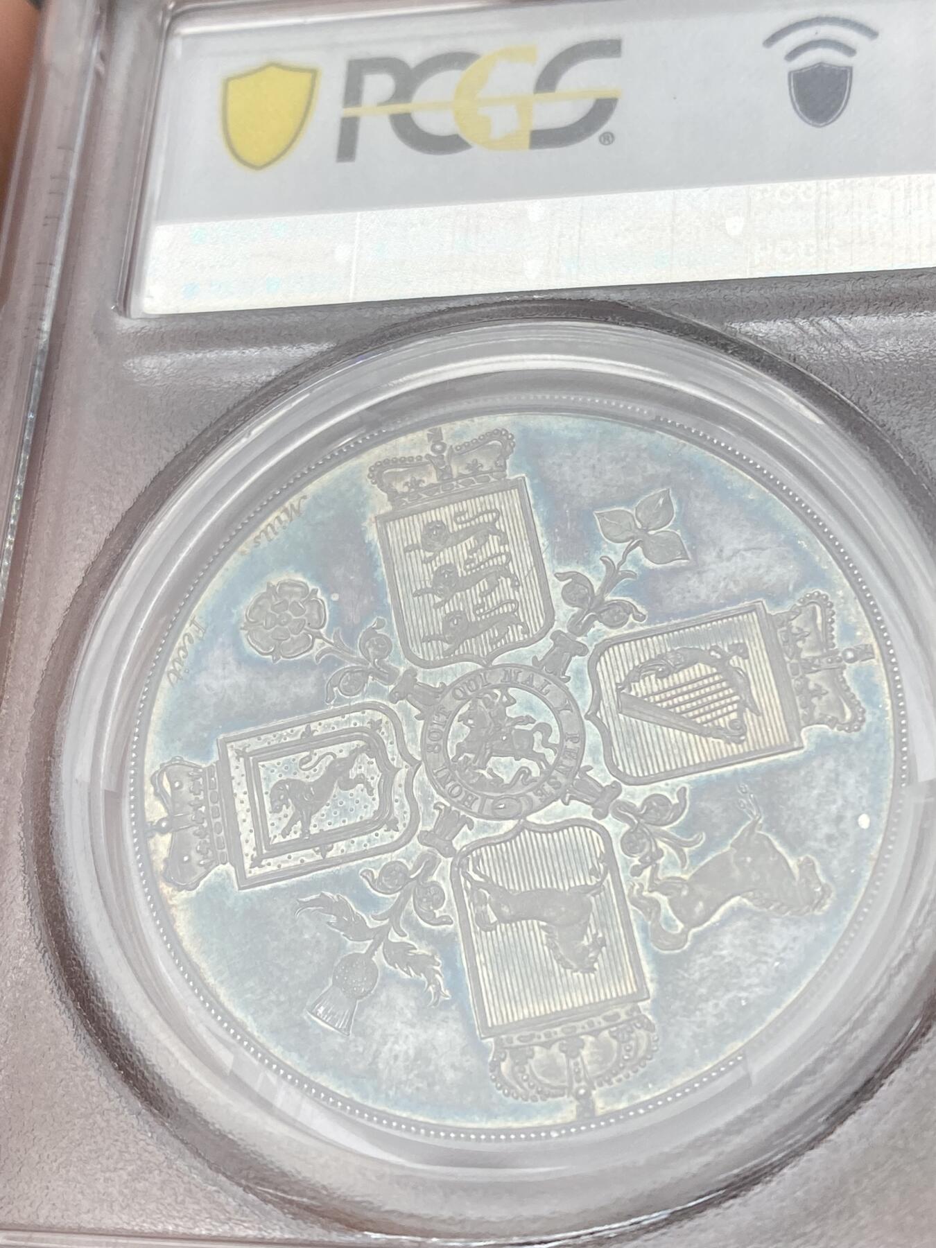 万国钱币拍卖第035期（金银流霞●万国秋季大拍） PCGS PR64DCAM 1820年英国乔治三世克朗样币 乔治三世样币系列中非常稀有的一枚，由Thomas Webb和George Mills两位雕模师联合创作，背面采用了查理二世时期引入的十字盾徽设计，四种徽章围绕着嘉德勋章内的圣乔治屠龙，其中汉诺威战马致敬了乔治三世的日耳曼血统。超高浮雕，深度镜面，均匀的蓝绿色包浆更是锦上添花，原NGC PF65CAM砸盒，PCGS唯一冠军分。