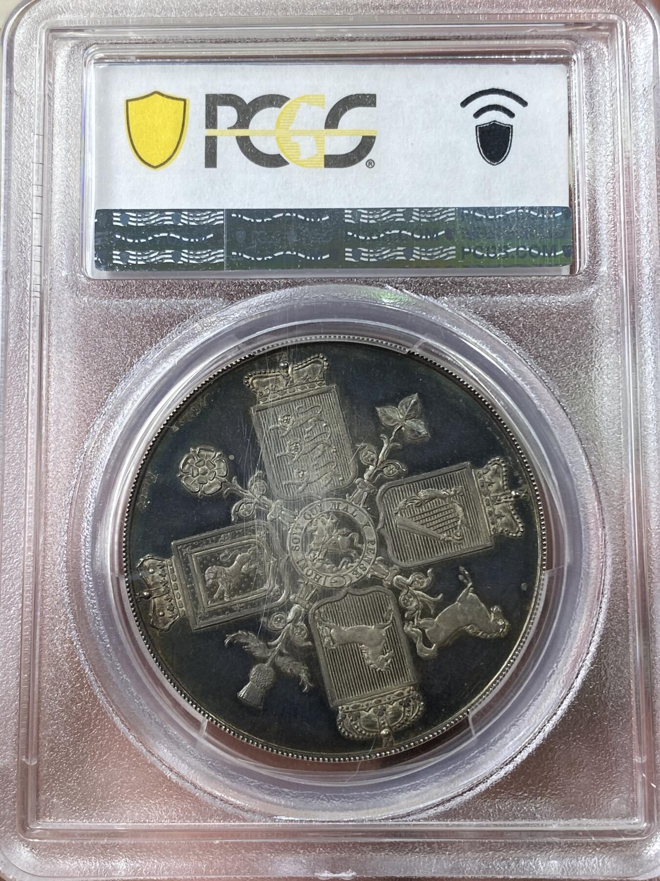 万国钱币拍卖第035期（金银流霞●万国秋季大拍） PCGS PR64DCAM 1820年英国乔治三世克朗样币 乔治三世样币系列中非常稀有的一枚，由Thomas Webb和George Mills两位雕模师联合创作，背面采用了查理二世时期引入的十字盾徽设计，四种徽章围绕着嘉德勋章内的圣乔治屠龙，其中汉诺威战马致敬了乔治三世的日耳曼血统。超高浮雕，深度镜面，均匀的蓝绿色包浆更是锦上添花，原NGC PF65CAM砸盒，PCGS唯一冠军分。