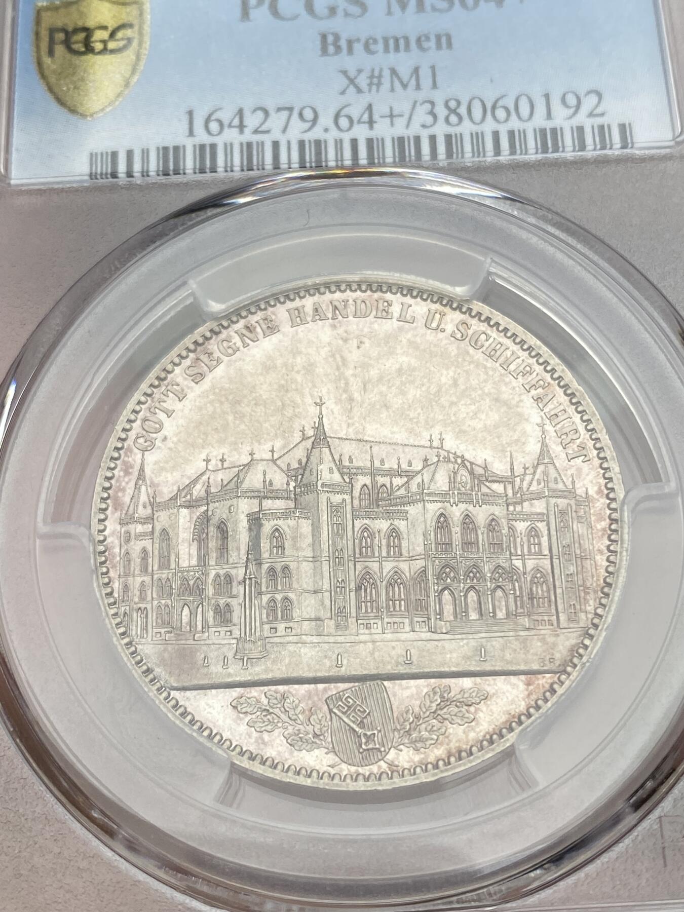 万国钱币拍卖第035期（金银流霞●万国秋季大拍） PCGS MS64+ 1864年不莱梅证券交易所纪念流通1泰勒 镜面与青瓷色包浆兼得的名誉品种 汉诺威造币厂精工之作 发行量仅5000枚 不莱梅市徽上方刊德文“上帝保佑贸易与航运”这座美丽的新哥特风格建筑在1943年毁于战火 庆幸的是还能在此币上欣赏她的美丽