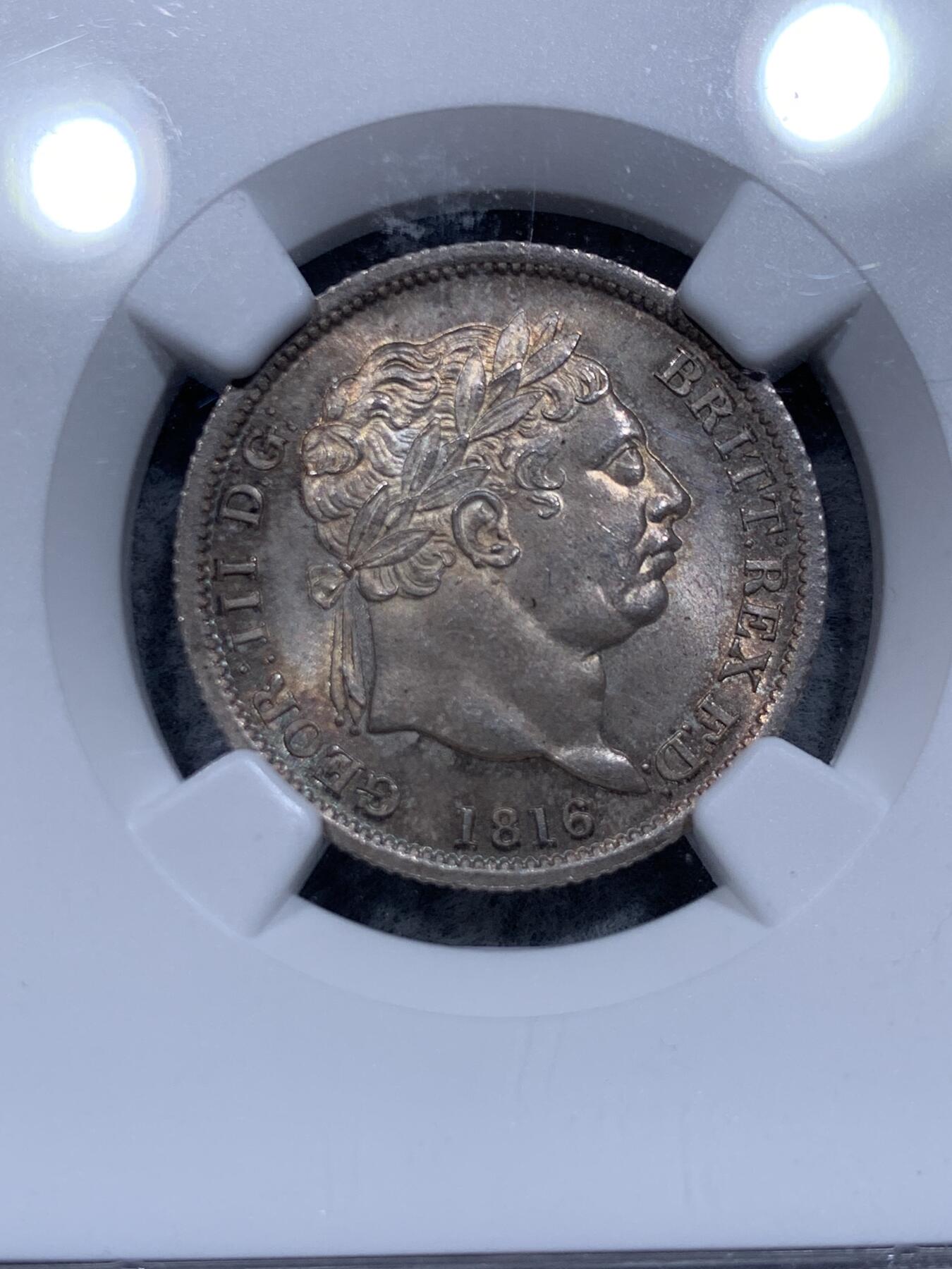 《竞宝斋》第315场 周日，周一，周二  3场连拍 （全场包邮） NGC MS65 英国1816年 乔治三世牛头1先令银币。好包浆好状态，来自皮斯特鲁奇的经典设计，分数够玩了，稀奇有2750的落槌价。
