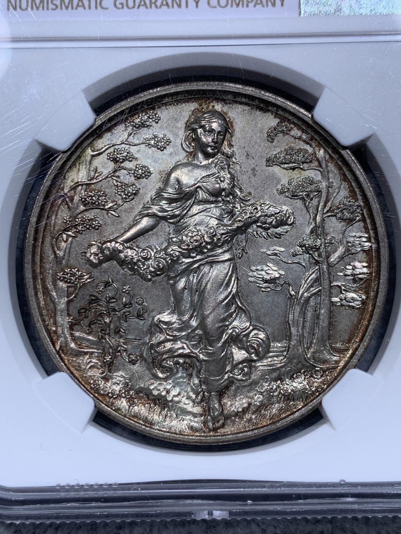 《竞宝斋》第315场 周日，周一，周二  3场连拍 （全场包邮） NGC MS64 稀见德国园艺镀银大铜章，Eoster女神手捧花环，赤脚悠然自得行走在软绵的草地中，迎风而来面带笑意，长发飘逸。深浮雕形象生动。MS64高分