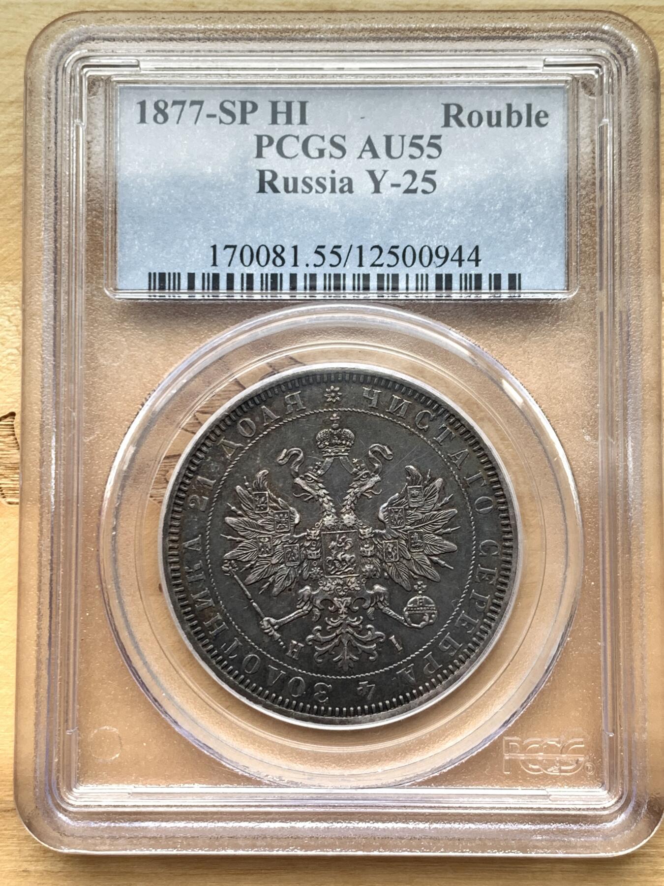《竞宝斋》第327场 周日，周一，2场连拍 （全场包邮） PCGS AU55 俄国1877年亚历山大二世时期1卢布银币，双头鹰胸前为圣乔治屠龙的盾徽，盾徽被圣安德烈勋章环绕，链章上部两个带X的圆形饰物通常弱打或是磨平，即便MS级能看清的也很少，这枚已经很不错了。