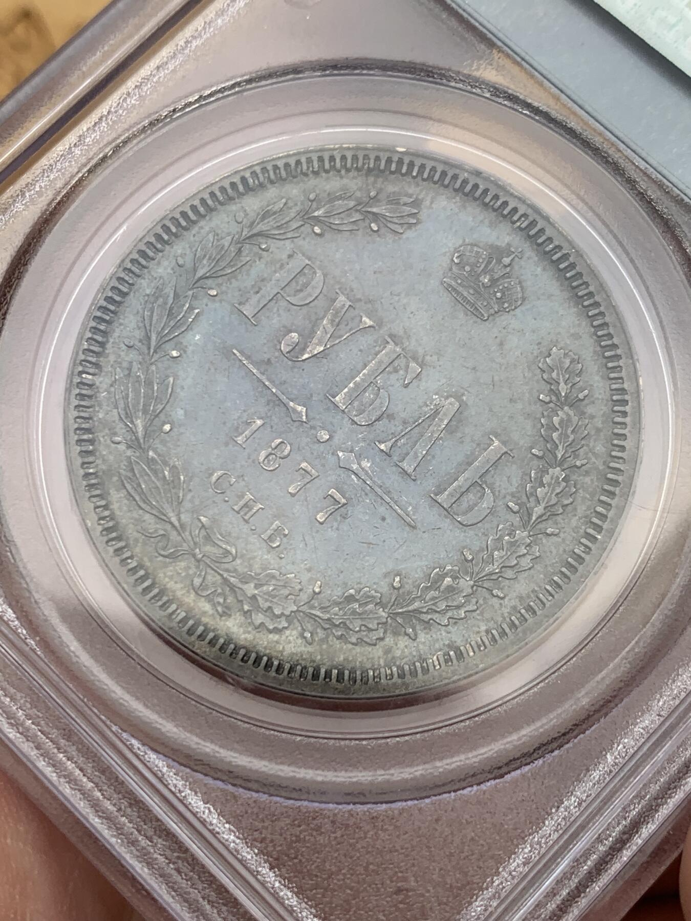 《竞宝斋》第327场 周日，周一，2场连拍 （全场包邮） PCGS AU55 俄国1877年亚历山大二世时期1卢布银币，双头鹰胸前为圣乔治屠龙的盾徽，盾徽被圣安德烈勋章环绕，链章上部两个带X的圆形饰物通常弱打或是磨平，即便MS级能看清的也很少，这枚已经很不错了。