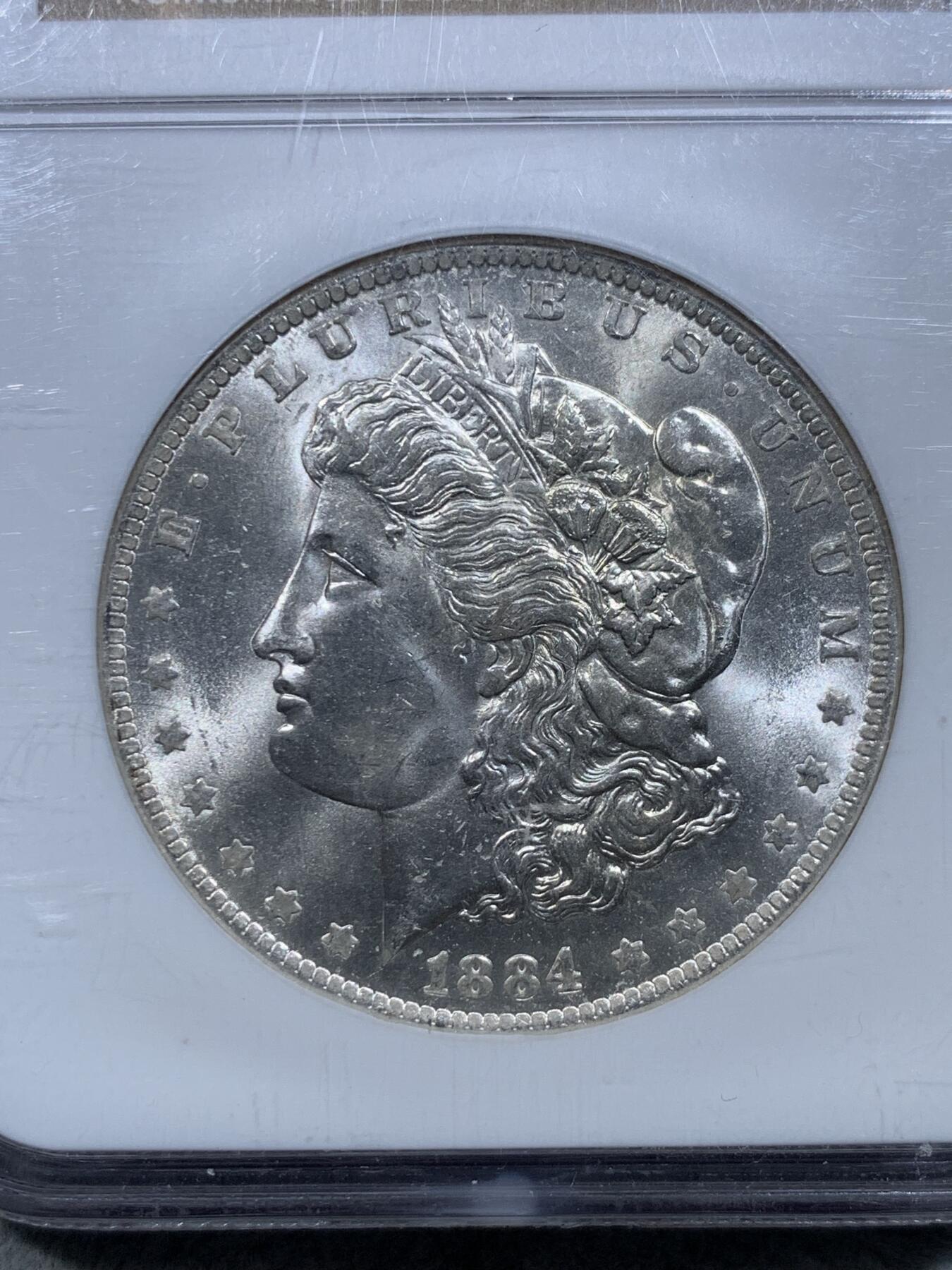 《竞宝斋》第326场 周日，周一，2场连拍 （全场包邮） NGC  MS64  美国1884年O版摩根银币，ngc老盒严评，无官网图，但终身保真。两面爆霜底板，出厂状态银霜，脸部无明显伤很少见。状态好于分数。
