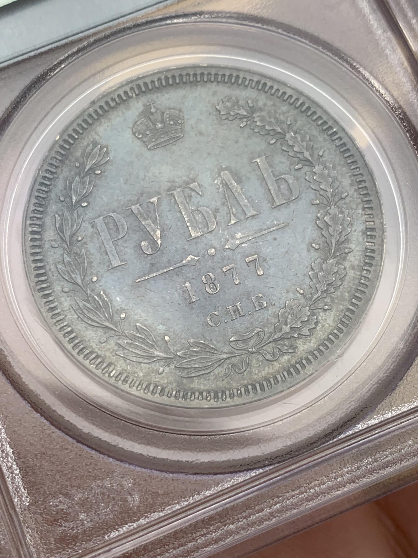 《竞宝斋》第327场 周日，周一，2场连拍 （全场包邮） PCGS AU55 俄国1877年亚历山大二世时期1卢布银币，双头鹰胸前为圣乔治屠龙的盾徽，盾徽被圣安德烈勋章环绕，链章上部两个带X的圆形饰物通常弱打或是磨平，即便MS级能看清的也很少，这枚已经很不错了。