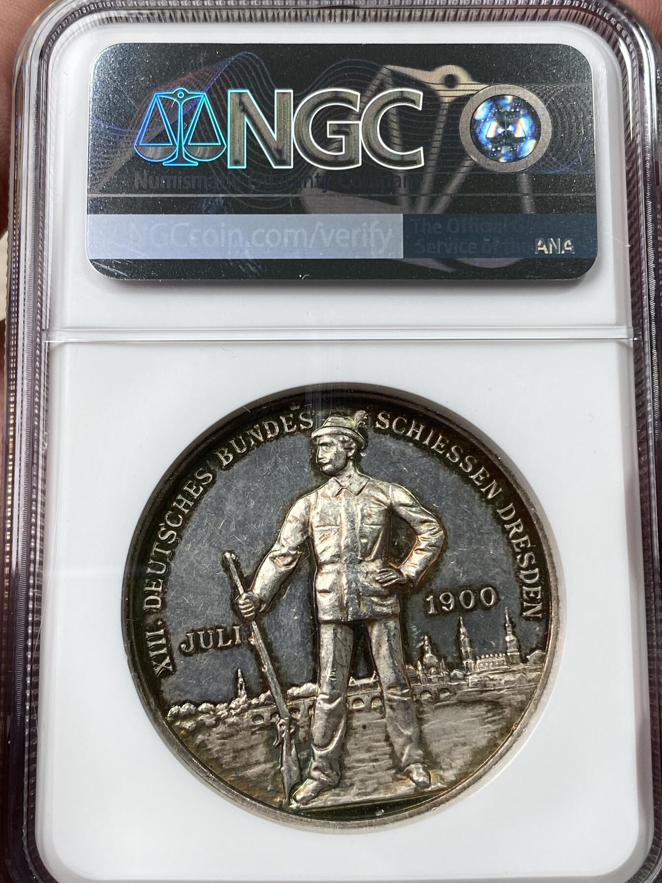 万国钱币拍卖第037期 NGC MS62DPL 1900年德国德累斯顿第十三届联邦射击节纪念银章 花环日耳曼尼娅女神与枪手景观的经典组合 超高浮雕意味着高品极难 此枚环七彩深度类镜面唯一顶级收藏品质