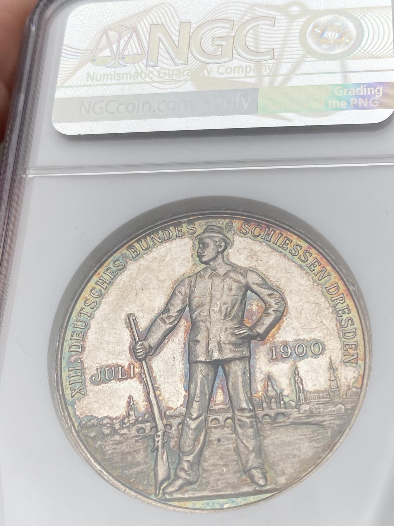 万国钱币拍卖第037期 NGC MS62DPL 1900年德国德累斯顿第十三届联邦射击节纪念银章 花环日耳曼尼娅女神与枪手景观的经典组合 超高浮雕意味着高品极难 此枚环七彩深度类镜面唯一顶级收藏品质