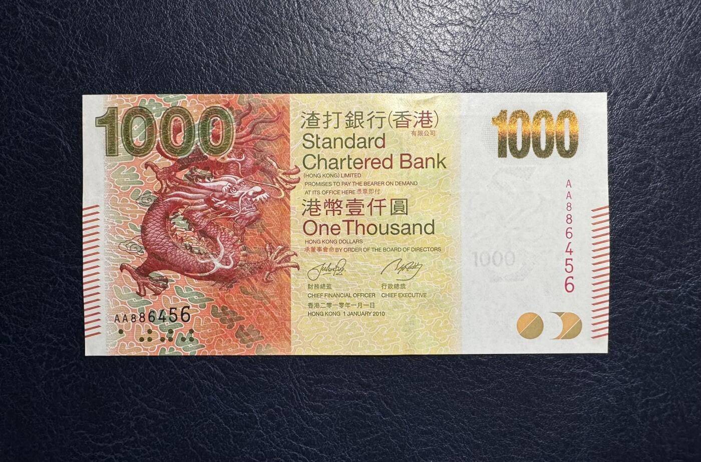 收藏联盟Quantum Auction 第394期拍卖  香港渣打银行2010年1000元首发AA冠 品相UNC 尾号456顺子 角尖微瑕以及滚轮印