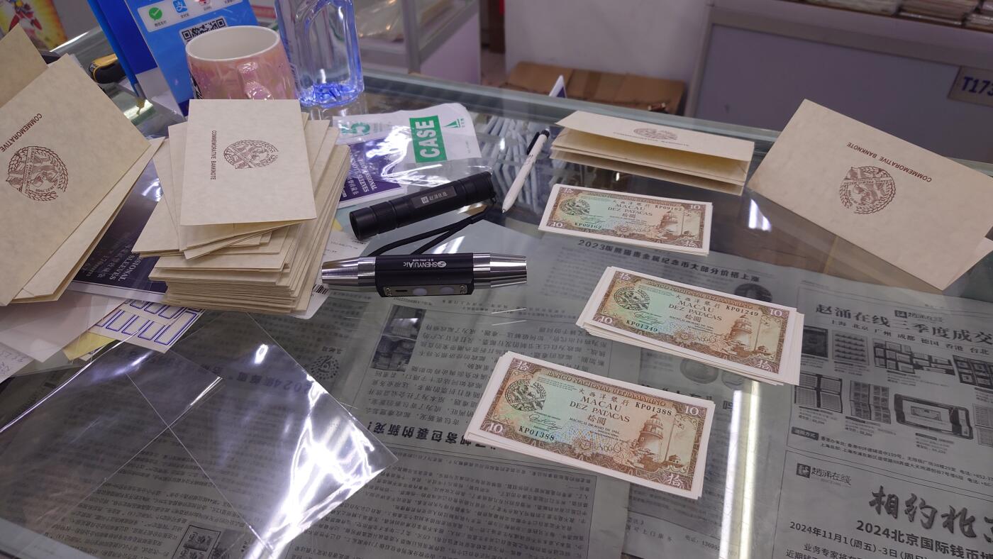 【世界钱币】精选微拍第151期暨2024年第63期～新到赛车钞群内卖剩货品选购～无胶水的几十张已经全部售罄，剩余的都有点轻微瑕疵 (预告11月底和12月上旬，12月中旬接连有币展新货群里卖剩款选购) 【一口价已售出】1988年澳门赛车纪念钞 全新UNC微瑕 号码无47尾号01386 (红圈处有一丁点黄胶水印非常轻微) 灯下无斑带原装册