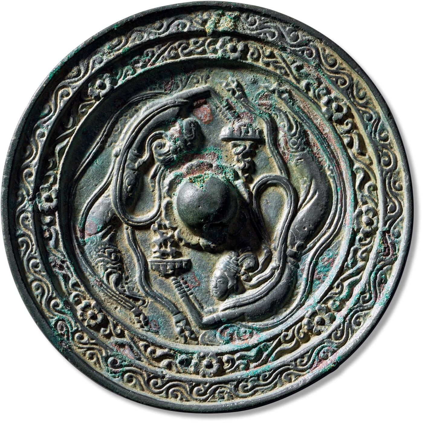 匡时2024年秋拍-中国历代钱币专场 双飞天镜一枚，直径：15.5cm，厚：1.2cm，重：1078g，极美品圆形，圆钮，钮两侧各饰一飞天，环钮相对，其头带宝冠，披帛下垂，天衣飘逸，双手持盘，图案细致入微，此镜甚为少见，极为精美。飞天，是佛教中干闼婆和紧那罗的化身。干闼婆，意译为天歌神、紧那罗，意译为天乐神。原是古印度神话中的娱乐神和歌舞神，是一对夫妻，后被佛教吸收为天龙八部众神之一。干闼婆的任务是在佛国里散发香气，为