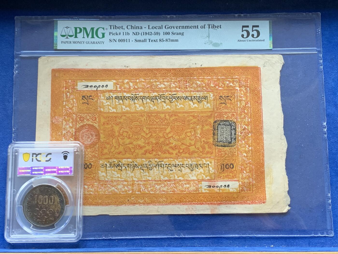 《竞宝斋》第341场 周日，周一，2场连拍 （全场包邮） PMG-55分 西藏1942年100两桑康藏钞 最大面值最大票幅 正面一对人身狮五面王托举聚宝盆，八宝图案环绕，背面老仙 仙鹤 童子 梅花鹿，色彩鲜艳华丽，可兑换一百枚章噶银币，如此品相保存下来殊为难得 细节见图