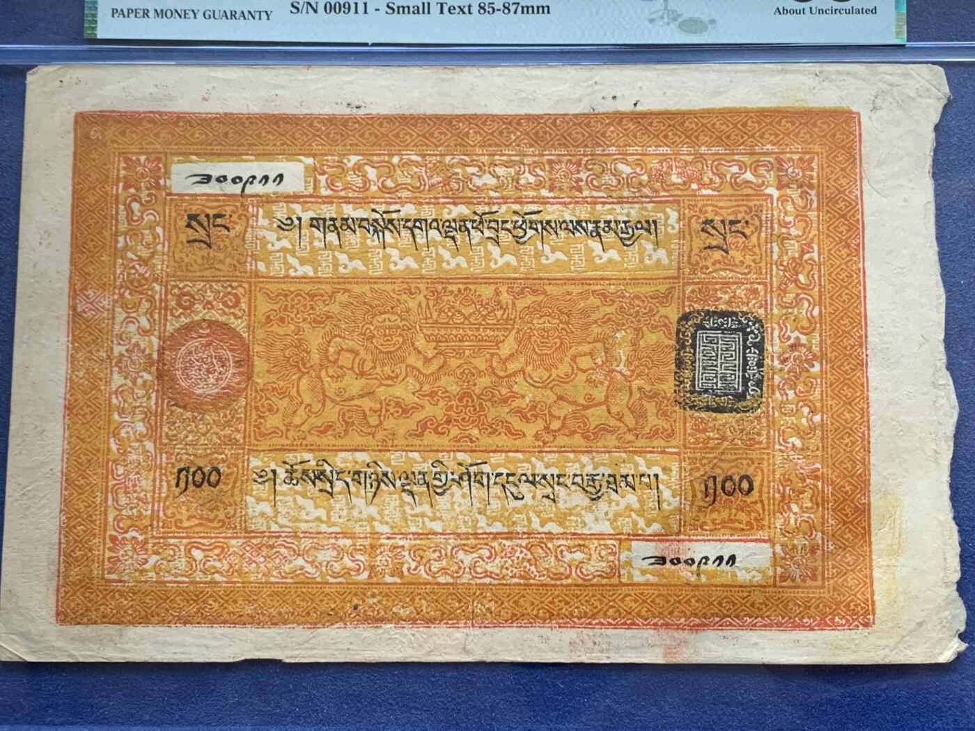 《竞宝斋》第341场 周日，周一，2场连拍 （全场包邮） PMG-55分 西藏1942年100两桑康藏钞 最大面值最大票幅 正面一对人身狮五面王托举聚宝盆，八宝图案环绕，背面老仙 仙鹤 童子 梅花鹿，色彩鲜艳华丽，可兑换一百枚章噶银币，如此品相保存下来殊为难得 细节见图