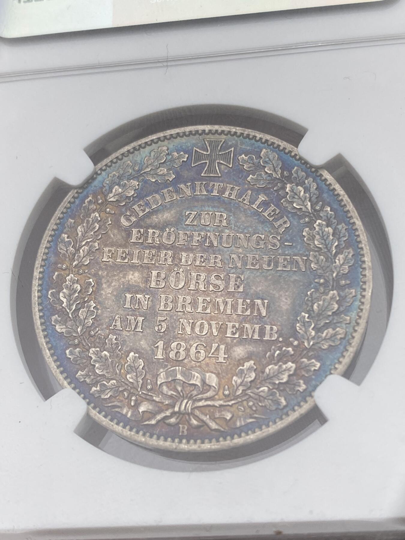 万国钱币拍卖第040期（万国2025新年大拍） NGC MS61 1864年不莱梅自由是证券交易所泰勒 联合泰勒名誉品之一  汉诺威造币厂铸造 发行量仅5000枚 原味五彩包浆 不莱梅市徽上方刊德文“上帝保佑贸易与航运”这座美丽的新哥特风格建筑在1943年毁于战火 庆幸的是还能在此币上欣赏她的美丽