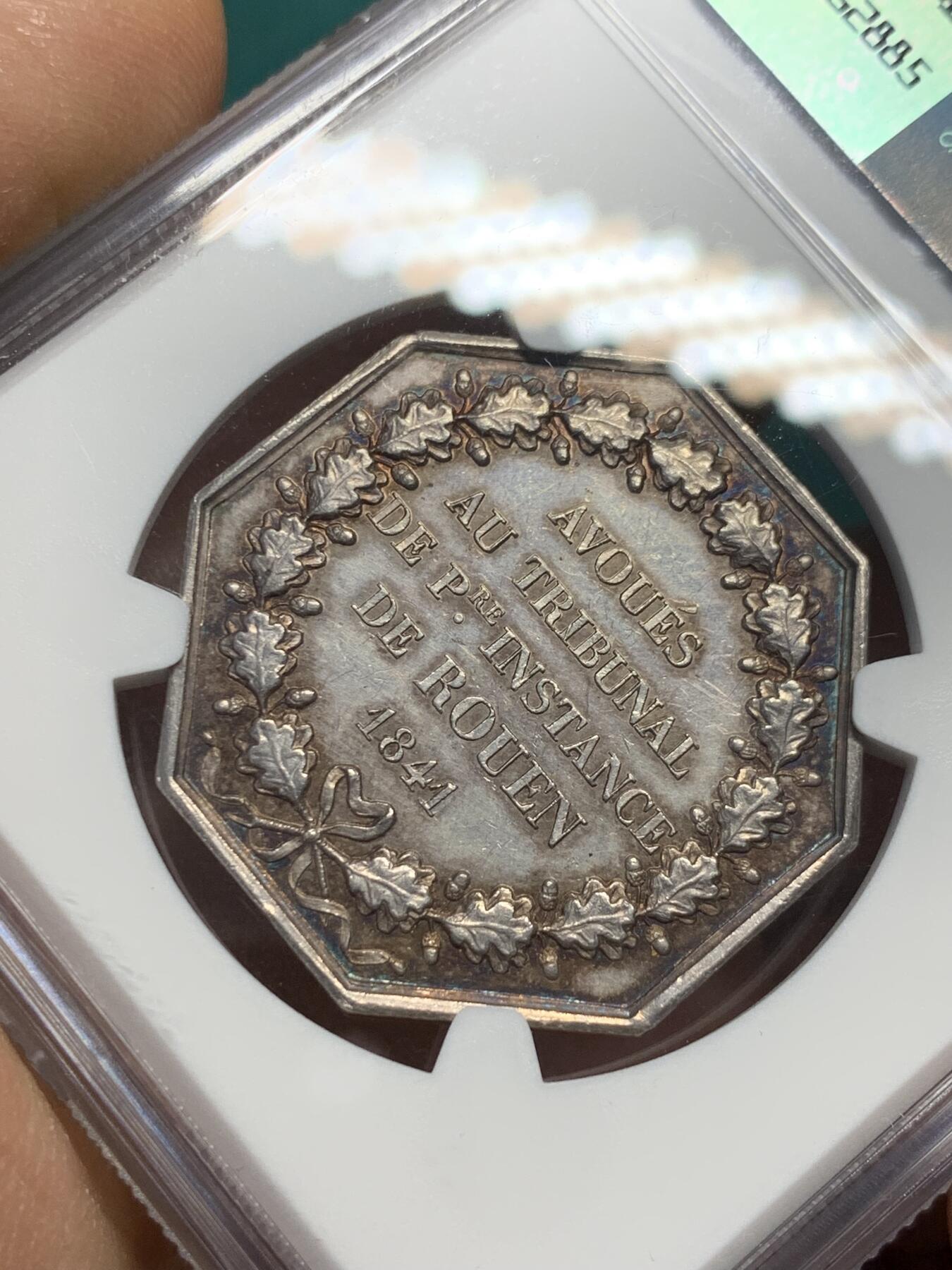 《竞宝斋》第344场 周日，周一，2场连拍 （全场包邮） NGC MS62 少见品 法国1841鲁昂法庭八角银章，法国八角银币，油灯边铭。正面图像：正义女神坐在鲁昂大教堂前，右手拿着象征正义的天平，称量对质双方的证词，左手依靠在一本巨大的法典上。反面文字：1841年由鲁昂第一审法庭审理)和橡树花环。雕刻师：DUBOIS。