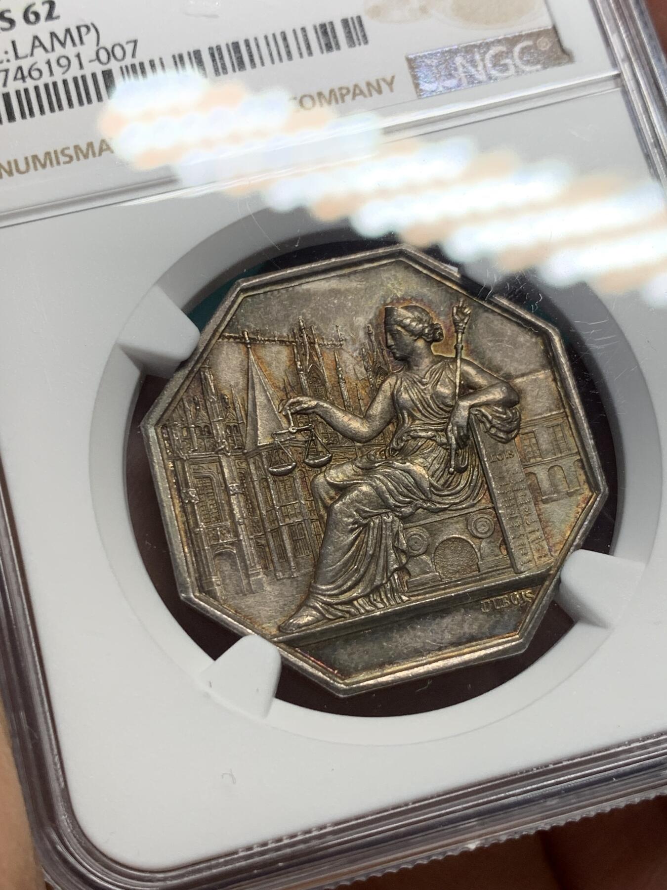 《竞宝斋》第344场 周日，周一，2场连拍 （全场包邮） NGC MS62 少见品 法国1841鲁昂法庭八角银章，法国八角银币，油灯边铭。正面图像：正义女神坐在鲁昂大教堂前，右手拿着象征正义的天平，称量对质双方的证词，左手依靠在一本巨大的法典上。反面文字：1841年由鲁昂第一审法庭审理)和橡树花环。雕刻师：DUBOIS。
