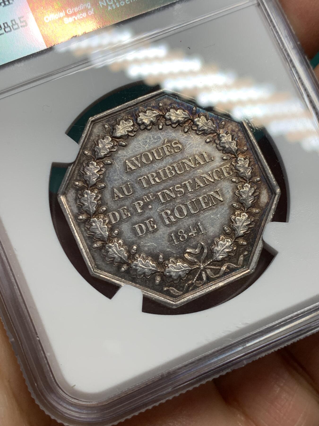 《竞宝斋》第344场 周日，周一，2场连拍 （全场包邮） NGC MS62 少见品 法国1841鲁昂法庭八角银章，法国八角银币，油灯边铭。正面图像：正义女神坐在鲁昂大教堂前，右手拿着象征正义的天平，称量对质双方的证词，左手依靠在一本巨大的法典上。反面文字：1841年由鲁昂第一审法庭审理)和橡树花环。雕刻师：DUBOIS。