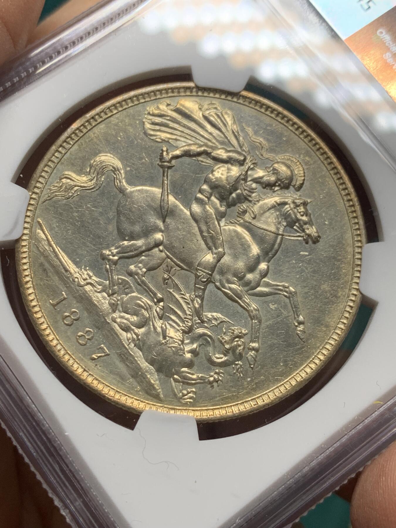 《竞宝斋》第344场 周日，周一，2场连拍 （全场包邮） NGC UNC 英国1887年维多利亚马剑克朗银币 整体金彩包浆