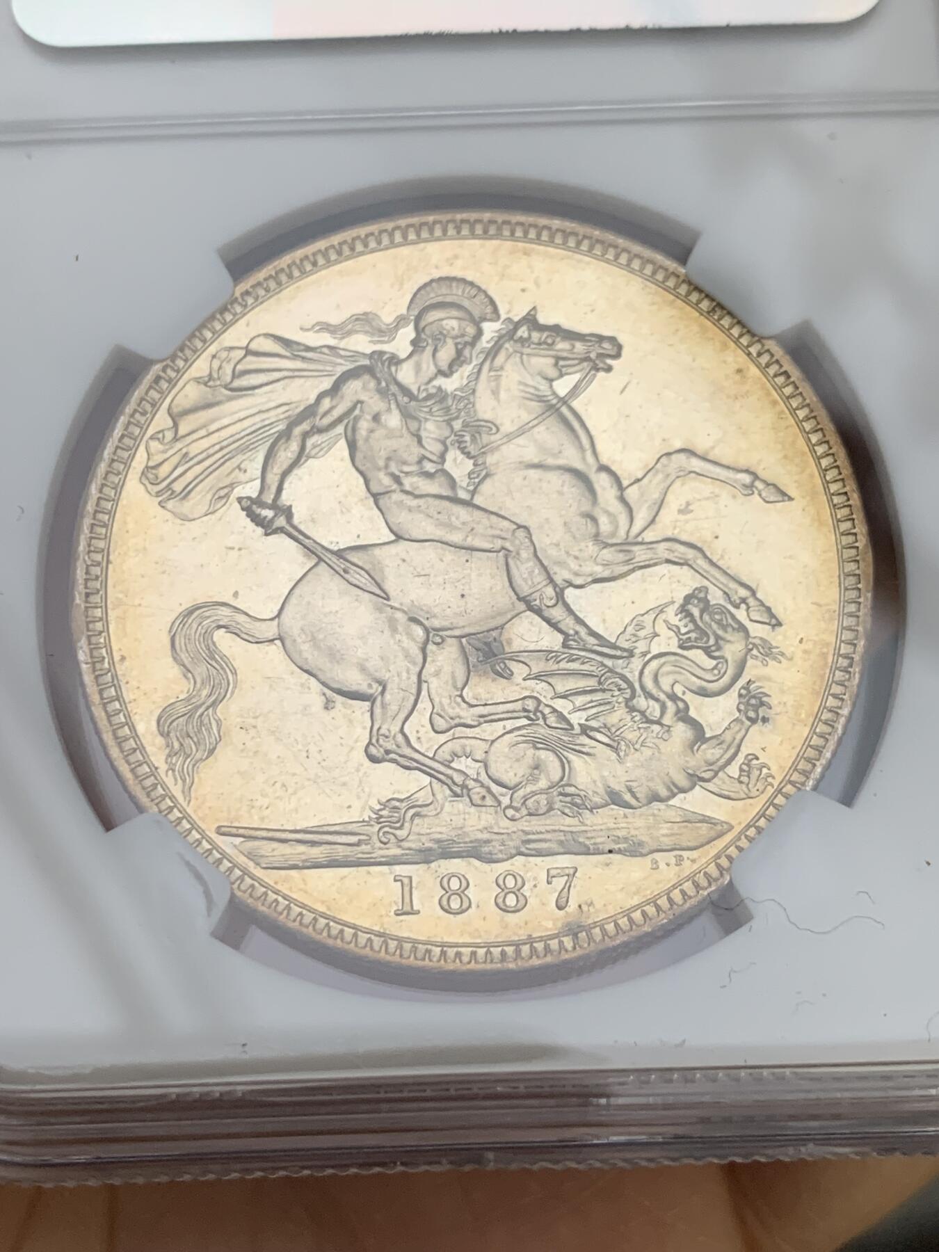 《竞宝斋》第344场 周日，周一，2场连拍 （全场包邮） NGC UNC 英国1887年维多利亚马剑克朗银币 整体金彩包浆