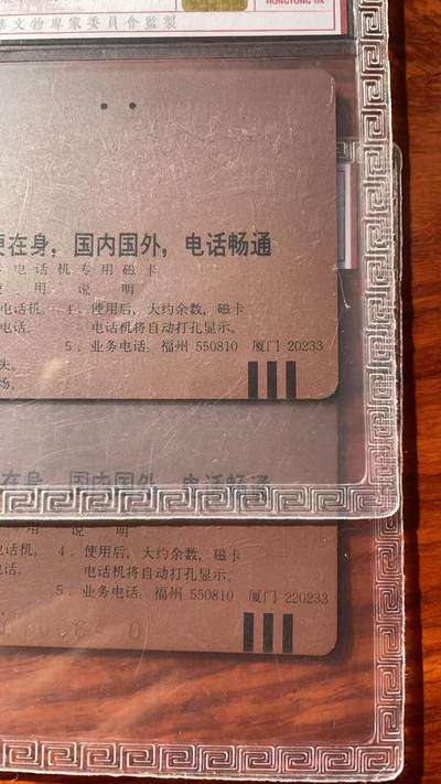 《卡拍》第320期拍卖1月25日晚22：10时延时截拍 福建田村卡《无编号移动电话广告（背面厦门电话号码5位数和6位数）》两枚旧卡，鸿通精装评级，五位数评分US64分（有一指甲折印），六位数有较多磨划评分US62分。