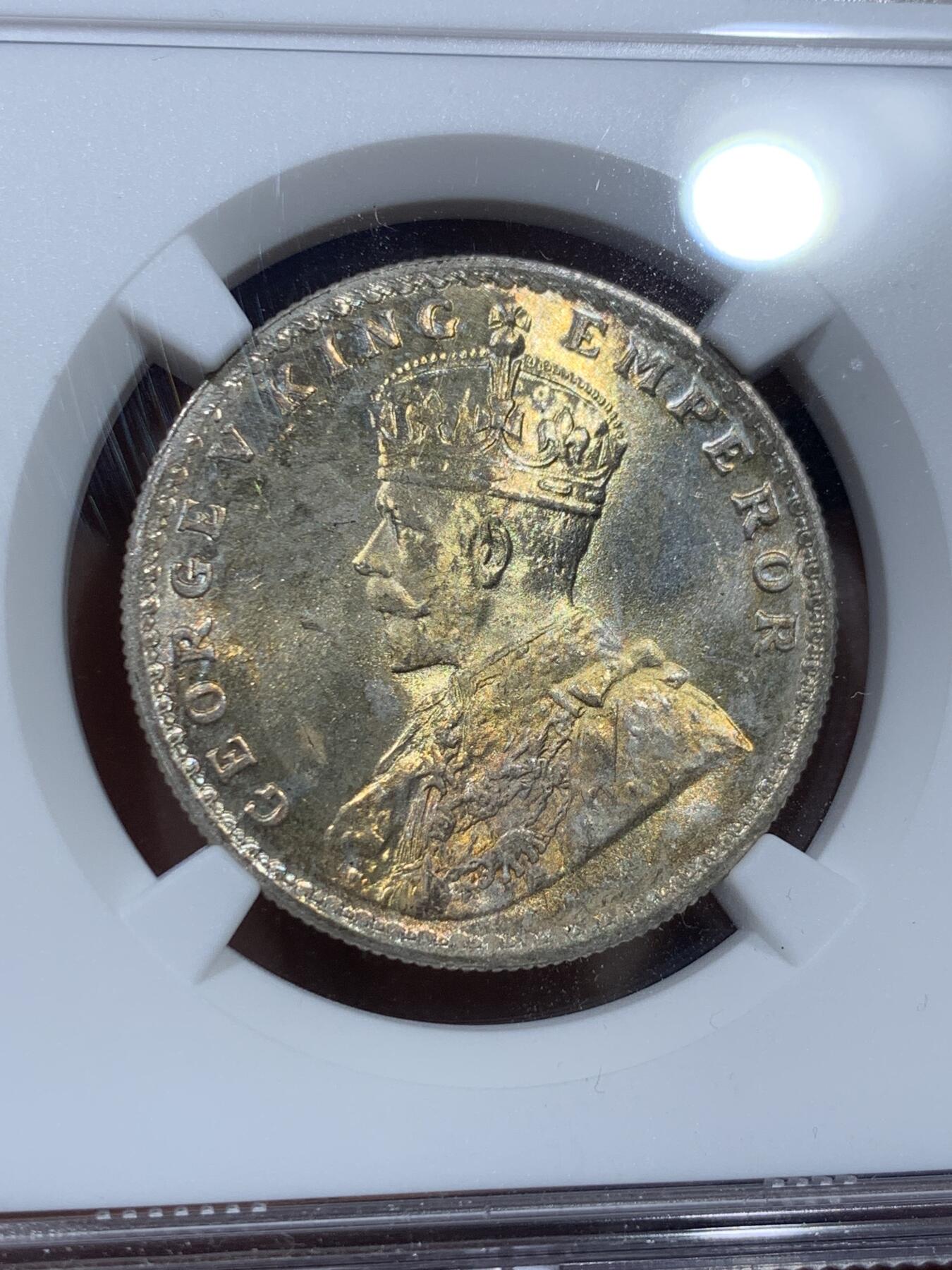 《竞宝斋》第351场 周日，周一 2场连拍 （全场包邮） NGC MS64 英属印度1918年乔治五世 1卢比银币 正面黄油光向橘黄色渐变，背面浅包浆银霜漂亮。63与64是卢比的一道坎，迈过了就算得上好品行列了，如果不想花几千块钱买65，那64就是适合你的性价比之选了。