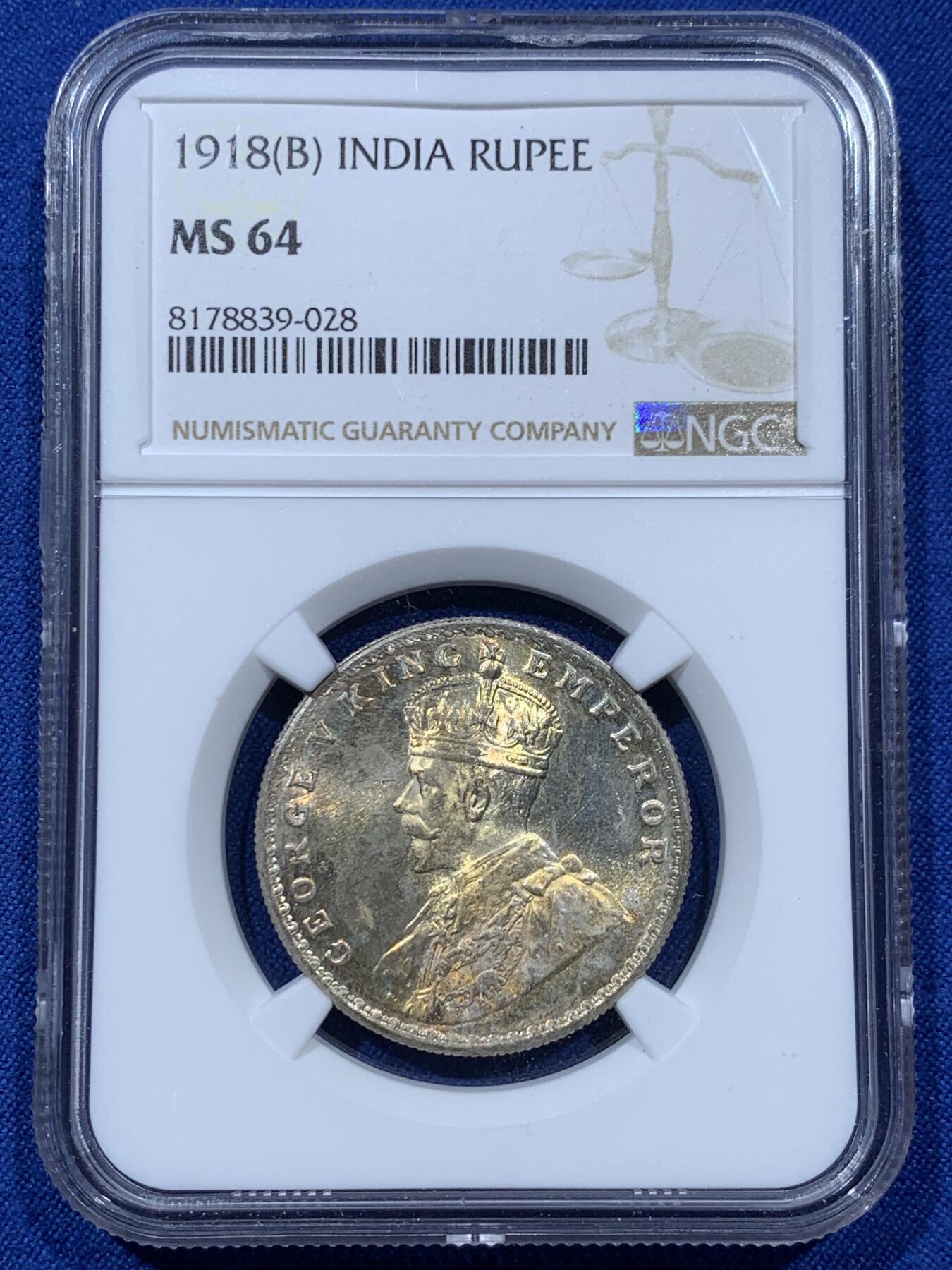 《竞宝斋》第351场 周日，周一 2场连拍 （全场包邮） NGC MS64 英属印度1918年乔治五世 1卢比银币 正面黄油光向橘黄色渐变，背面浅包浆银霜漂亮。63与64是卢比的一道坎，迈过了就算得上好品行列了，如果不想花几千块钱买65，那64就是适合你的性价比之选了。