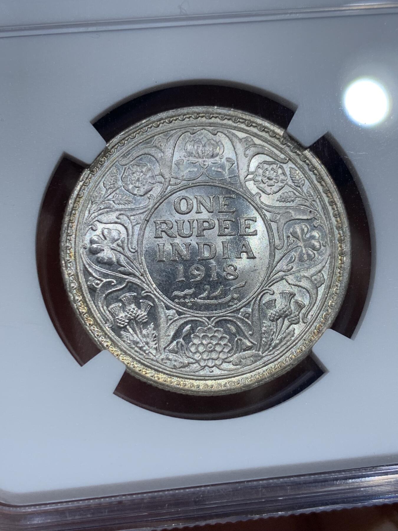 《竞宝斋》第351场 周日，周一 2场连拍 （全场包邮） NGC MS64 英属印度1918年乔治五世 1卢比银币 正面黄油光向橘黄色渐变，背面浅包浆银霜漂亮。63与64是卢比的一道坎，迈过了就算得上好品行列了，如果不想花几千块钱买65，那64就是适合你的性价比之选了。