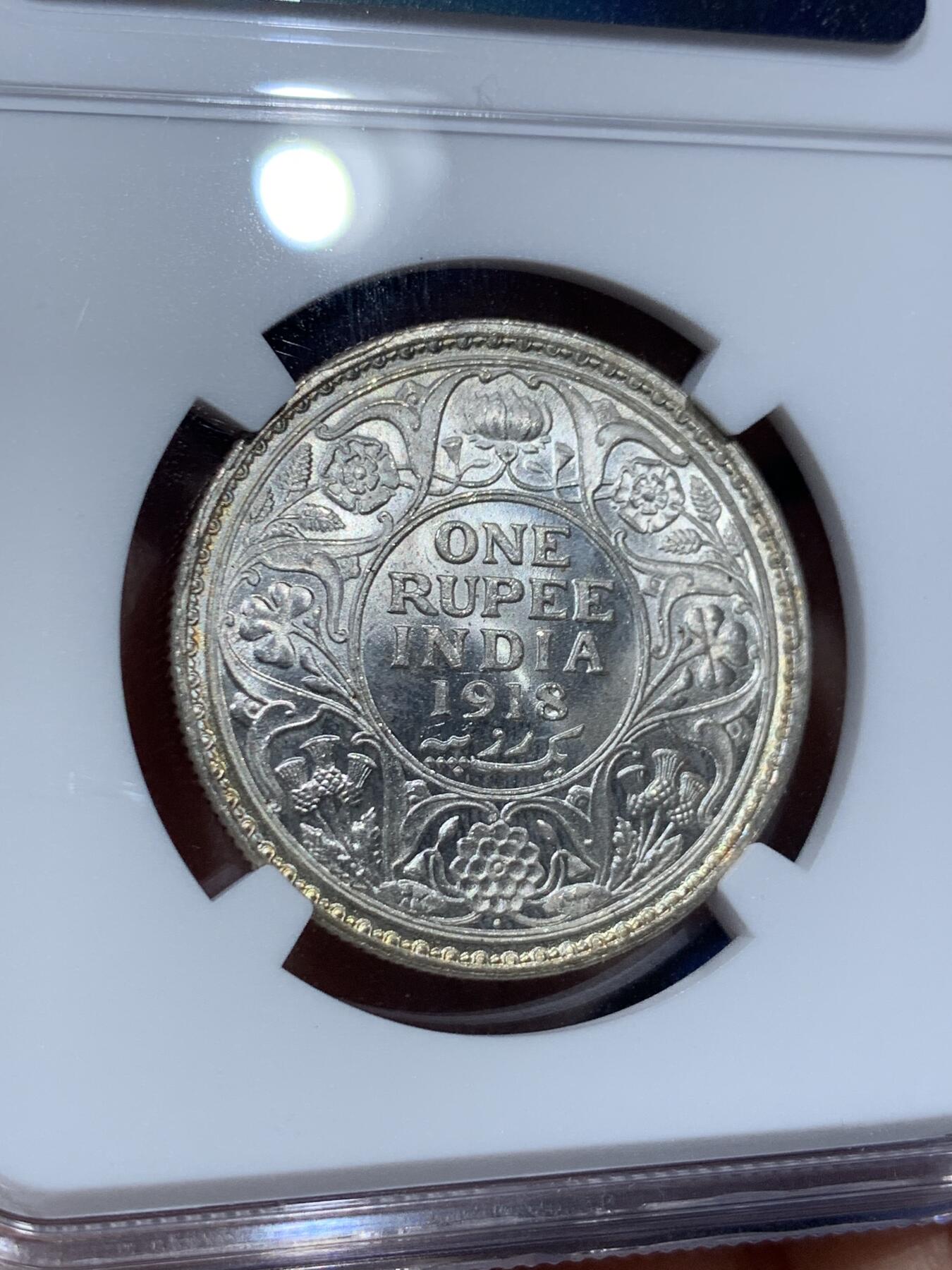 《竞宝斋》第351场 周日，周一 2场连拍 （全场包邮） NGC MS64 英属印度1918年乔治五世 1卢比银币 正面黄油光向橘黄色渐变，背面浅包浆银霜漂亮。63与64是卢比的一道坎，迈过了就算得上好品行列了，如果不想花几千块钱买65，那64就是适合你的性价比之选了。