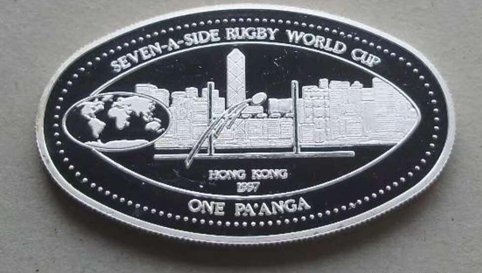 【币将精彩】世界钱币拍卖（2025-11-12） 汤加1997年香港橄榄球赛异形银币  925银25克，椭圆形，有镜面瑕疵，品如图。