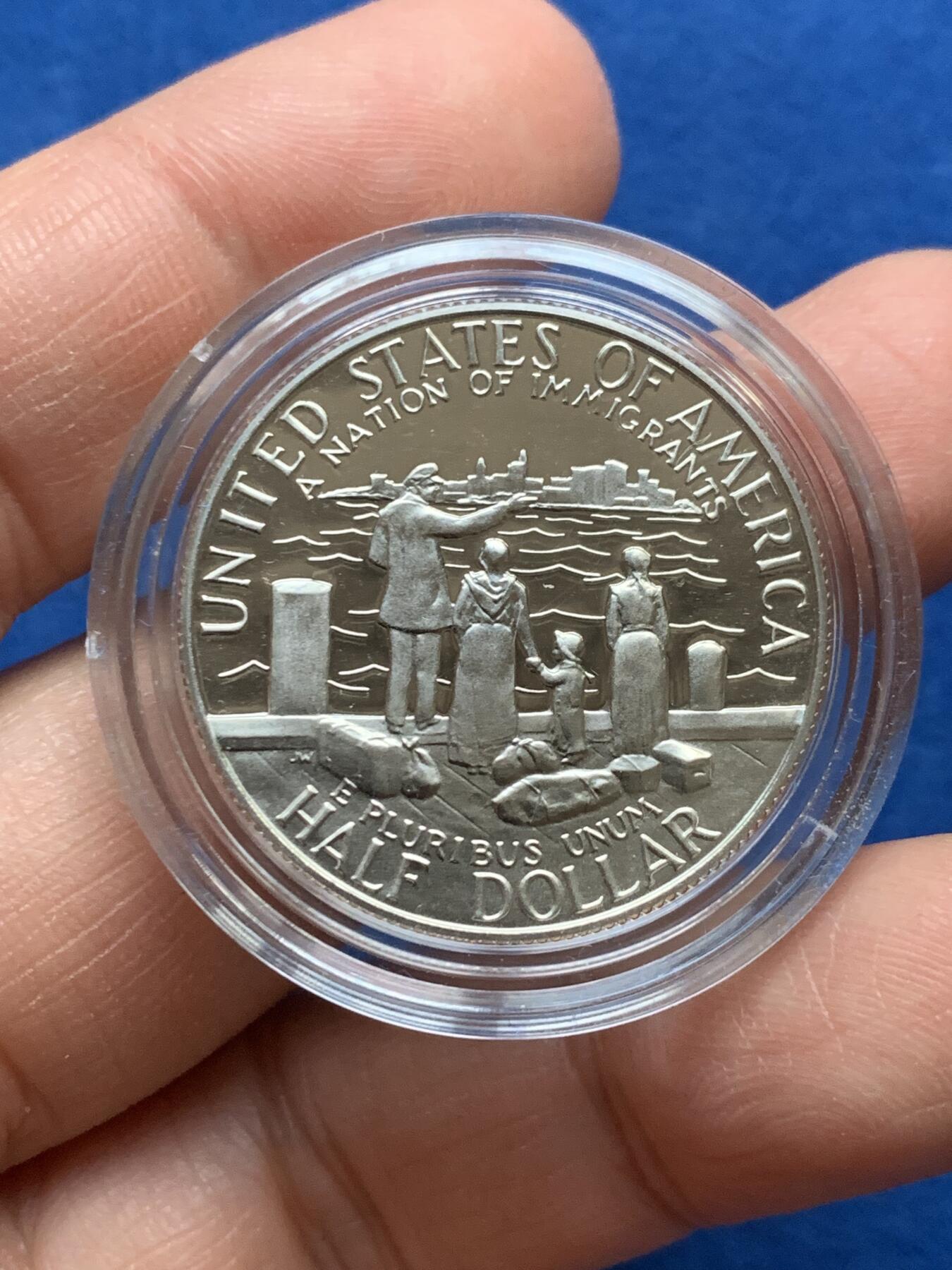 《竞宝斋》第353场 周日，周一，周二 3场连拍 （全场包邮） 美国1986年纪念自由女神像建成100周年精制银币套装。银币正面为庄严肃穆自由女神像，银币反面为自由女神像的火炬以及诗歌《新巨人》中的文字。 半美元铜镍币正面为纽约的天际线，自由女神像举起手臂，迎接一艘驶向纽约的班轮，太阳从东方升起，寓意着新世界新生活的开始。背面图案源自埃利斯岛上等待前往纽约的移民照片，反映了自由女神像作为移民希望象征的意义。