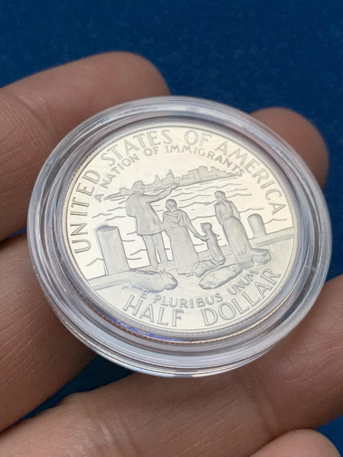 《竞宝斋》第353场 周日，周一，周二 3场连拍 （全场包邮） 美国1986年纪念自由女神像建成100周年精制银币套装。银币正面为庄严肃穆自由女神像，银币反面为自由女神像的火炬以及诗歌《新巨人》中的文字。 半美元铜镍币正面为纽约的天际线，自由女神像举起手臂，迎接一艘驶向纽约的班轮，太阳从东方升起，寓意着新世界新生活的开始。背面图案源自埃利斯岛上等待前往纽约的移民照片，反映了自由女神像作为移民希望象征的意义。