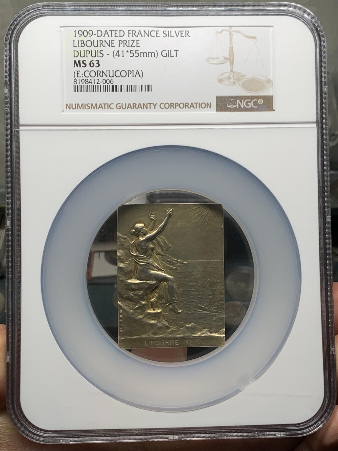《竞宝斋》第360场 周日，周一  2场连拍 （全场包邮） NGC MS63 法国拥抱朝阳镀金银章，大师迪布瓦 Henri Dubois（双面刻印）百年古董原版，巴黎造币厂精品章。极少见双面图案，正面少女端坐悬崖旁，张开双手拥抱清晨阳光，就如海子的诗“面向大海，春暖花开”。背面一小男孩趴在礁石上玩耍，远处帆船。55mm、56.21g 、950银，加大加厚盒。