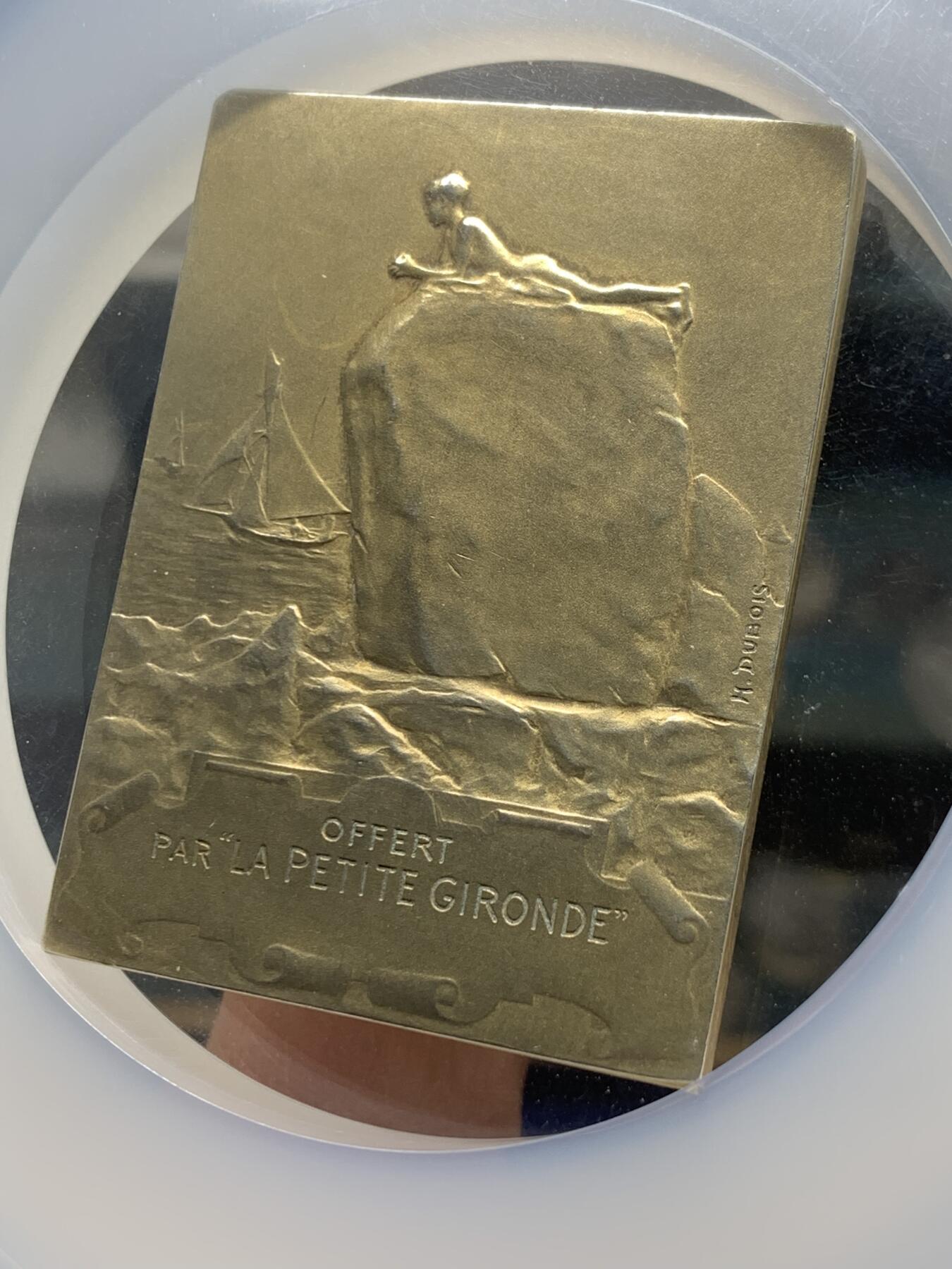 《竞宝斋》第360场 周日，周一  2场连拍 （全场包邮） NGC MS63 法国拥抱朝阳镀金银章，大师迪布瓦 Henri Dubois（双面刻印）百年古董原版，巴黎造币厂精品章。极少见双面图案，正面少女端坐悬崖旁，张开双手拥抱清晨阳光，就如海子的诗“面向大海，春暖花开”。背面一小男孩趴在礁石上玩耍，远处帆船。55mm、56.21g 、950银，加大加厚盒。