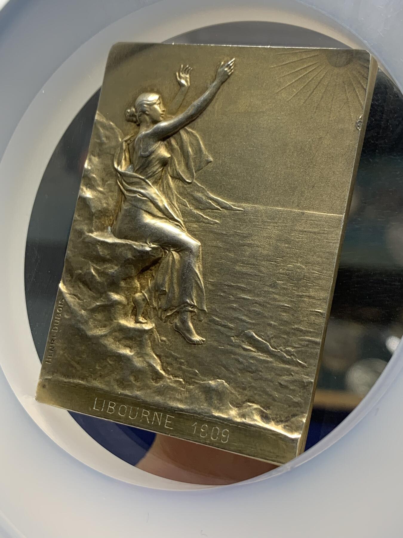 《竞宝斋》第360场 周日，周一  2场连拍 （全场包邮） NGC MS63 法国拥抱朝阳镀金银章，大师迪布瓦 Henri Dubois（双面刻印）百年古董原版，巴黎造币厂精品章。极少见双面图案，正面少女端坐悬崖旁，张开双手拥抱清晨阳光，就如海子的诗“面向大海，春暖花开”。背面一小男孩趴在礁石上玩耍，远处帆船。55mm、56.21g 、950银，加大加厚盒。