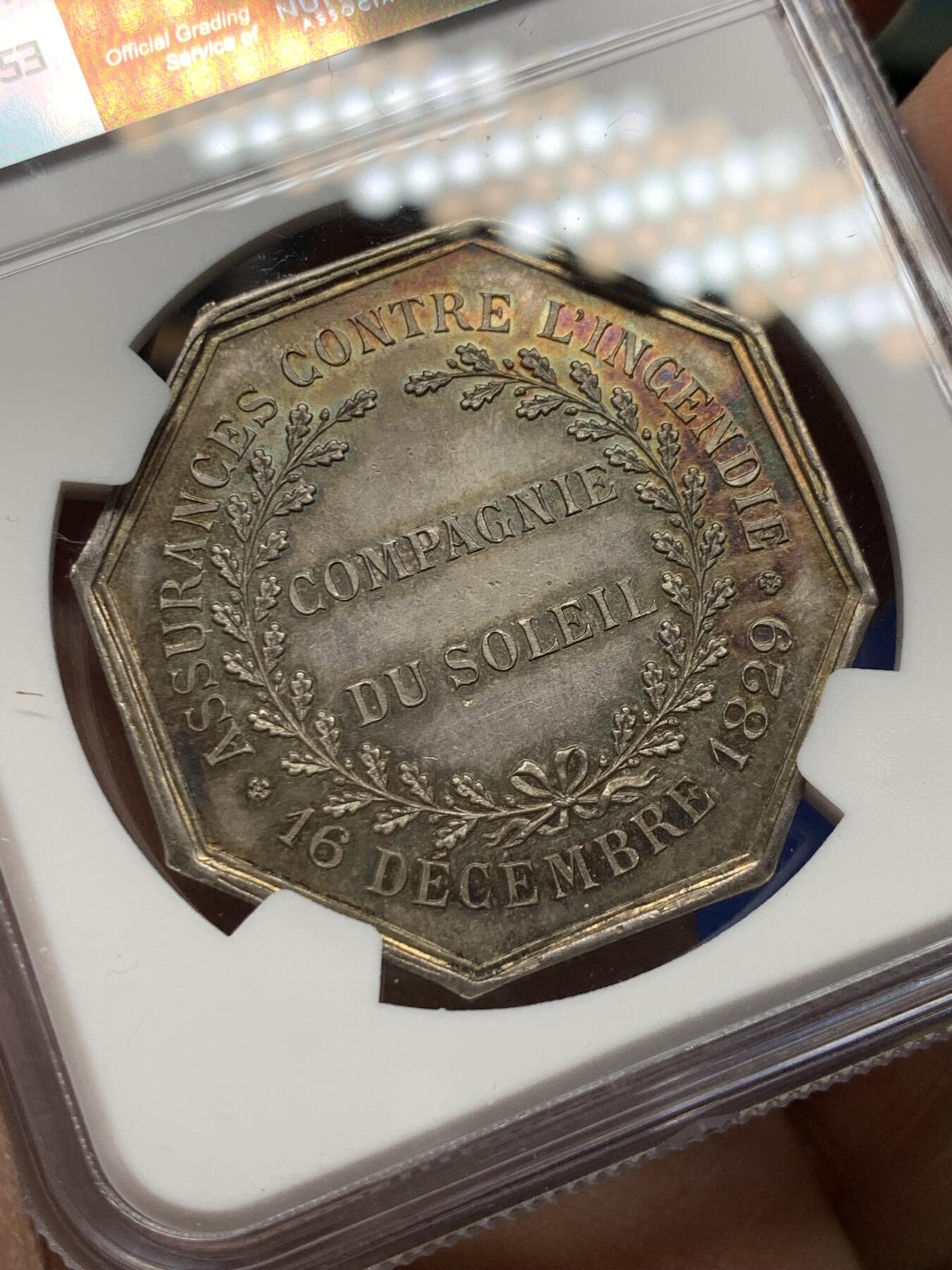 《竞宝斋》第360场 周日，周一  2场连拍 （全场包邮） NGC MS64 超高分 法国太阳保险八角银质代币。五彩包浆，品相佳。