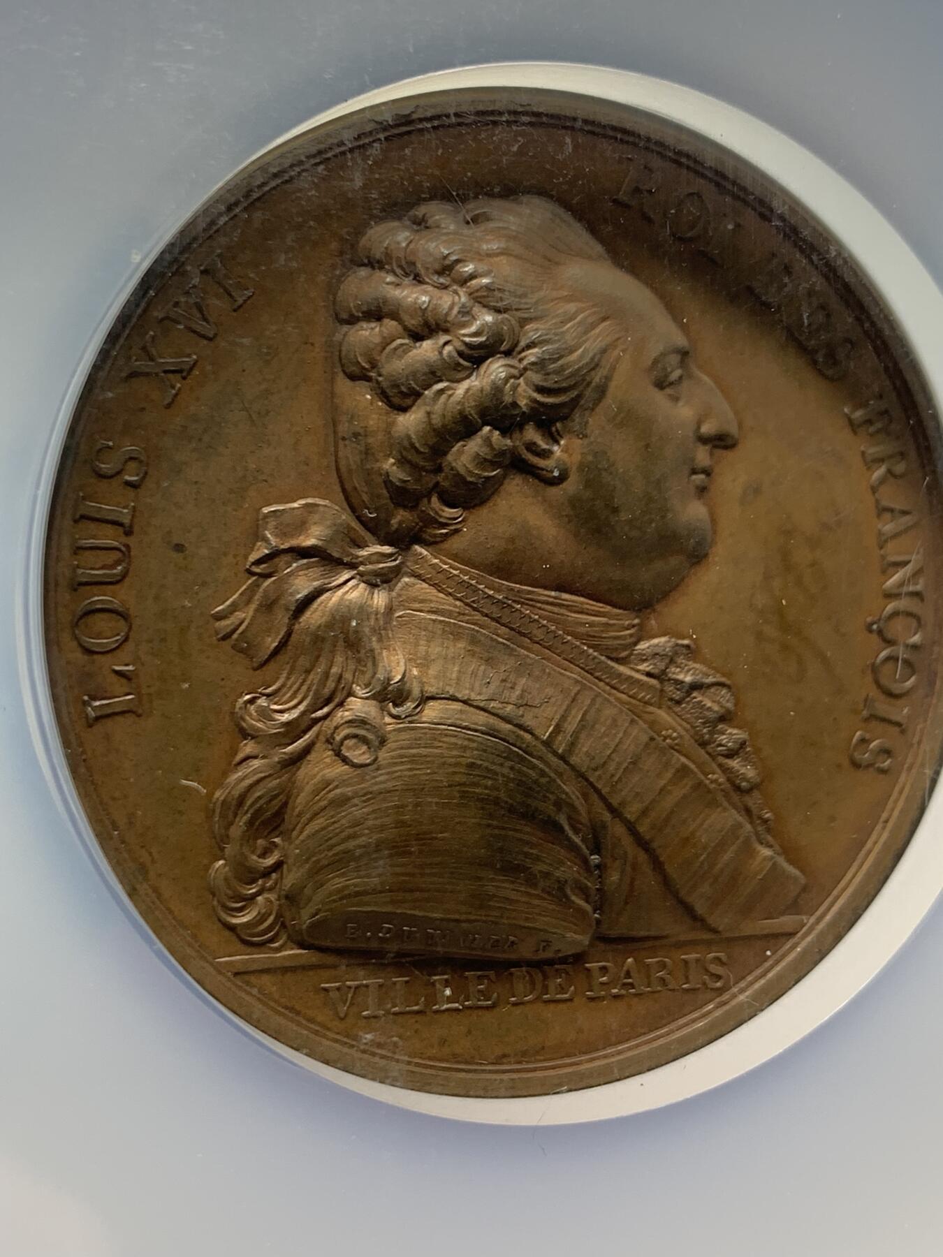 《竞宝斋》第360场 周日，周一  2场连拍 （全场包邮） NGC MS63BN 高分 1789年原铸，路易十六抵达巴黎(1789路易十六出逃事件），历史细节满满，不容错过的好章，值得收藏。正面图案路易十六半身像，签名：B.DUVIVIER.F。背面图案是路易十六全身像，紧随其后的是皇后玛丽-安托瓦内特牵着王太子的手，由巴黎领导人带往豪华酒店杜乐丽。