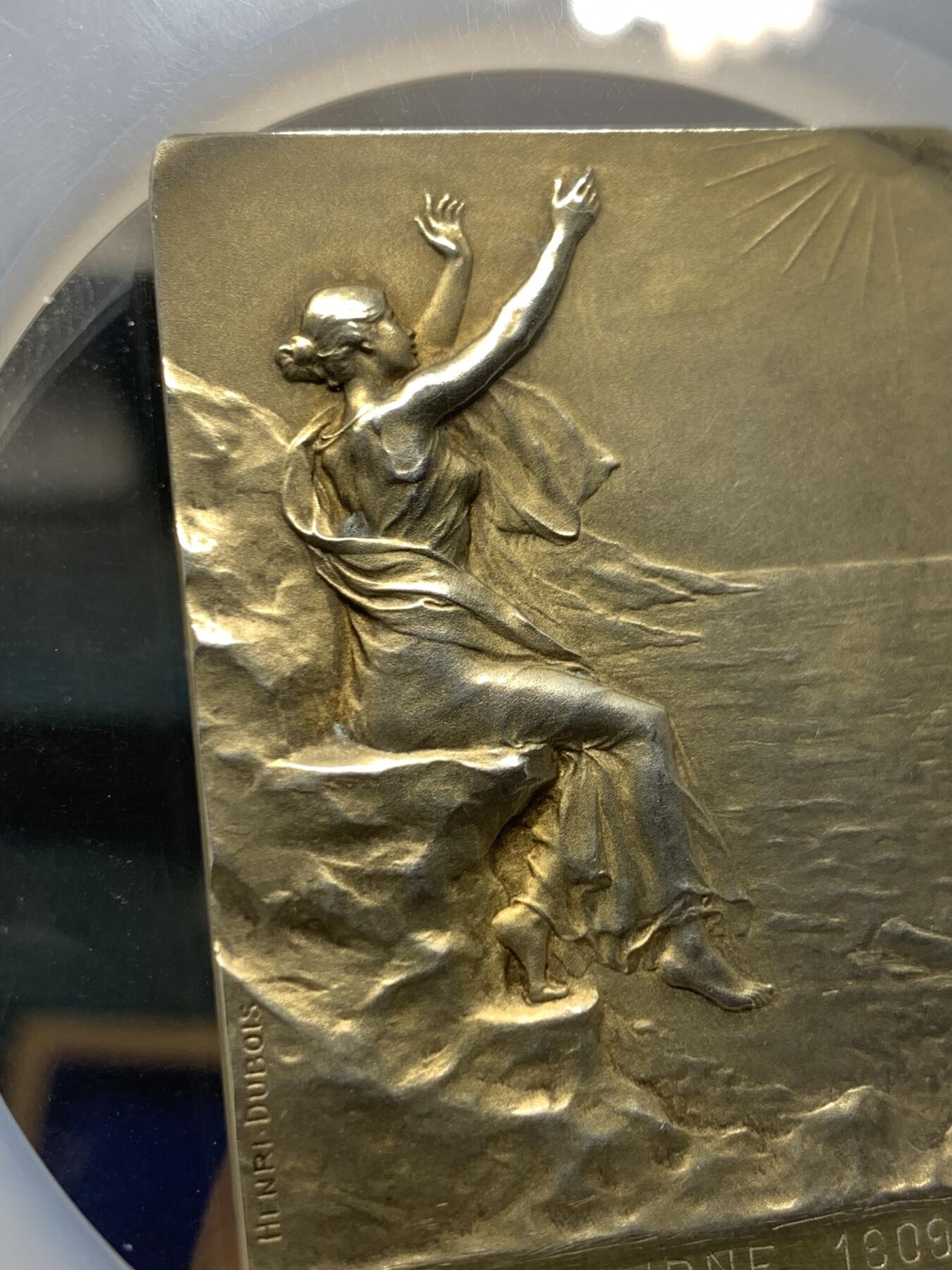 《竞宝斋》第360场 周日，周一  2场连拍 （全场包邮） NGC MS63 法国拥抱朝阳镀金银章，大师迪布瓦 Henri Dubois（双面刻印）百年古董原版，巴黎造币厂精品章。极少见双面图案，正面少女端坐悬崖旁，张开双手拥抱清晨阳光，就如海子的诗“面向大海，春暖花开”。背面一小男孩趴在礁石上玩耍，远处帆船。55mm、56.21g 、950银，加大加厚盒。