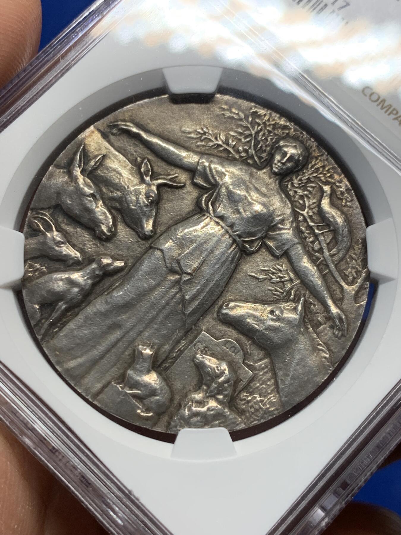 《竞宝斋》第361场 周日，周一  2场连拍 （全场包邮） NGC MS63 高分 首见品  动物保护协会铜镀银奖章。正面女神披着古老的披风，将她的手臂伸向聚集在她周围的动物身上，直径：39.5mm。
