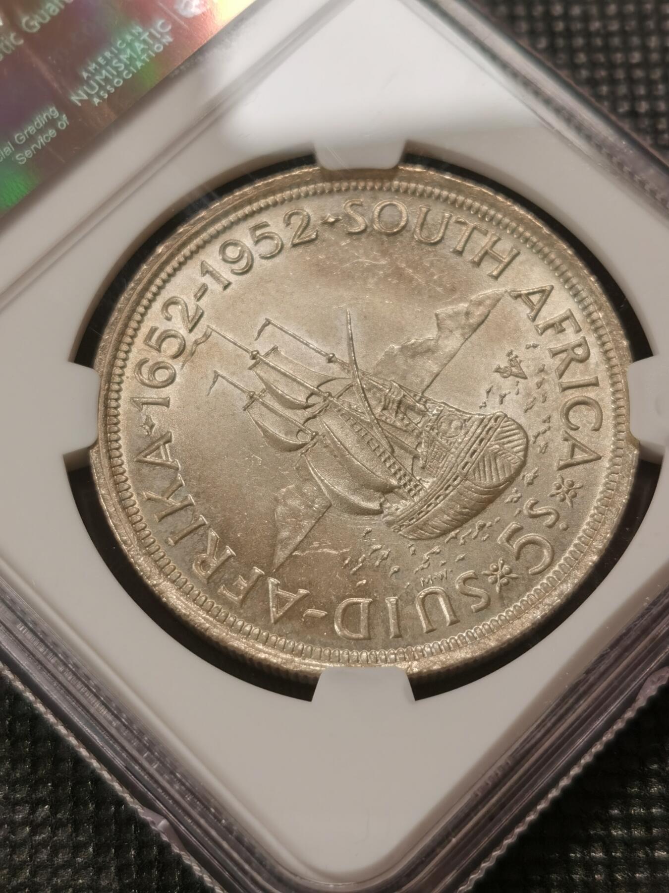 甄臻铺-世界钱币拍卖-南非西非东非专场（第10期）送拍享返佣金等优惠多多 NGC-MS64 南非 1952 乔治六世5先令 银币 发现开普敦300周年，品相难遇，大多63分，此枚64，自然淡黄油包浆