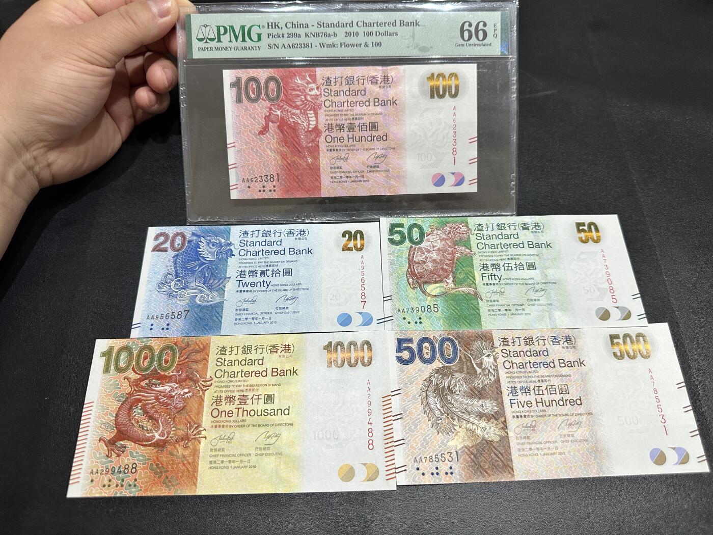 《外钞收藏家》第五百一十七期（五一假期畅拍场）（本平台长期征集拍品、欢迎联系） 香港渣打银行20、1000港币 五张一起 全新 100港币已评级PMG66 2010年AA冠全套