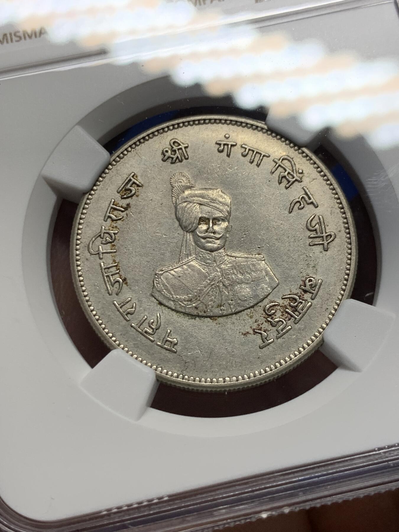 《竞宝斋》第370场 周日，周一 2场连拍 （全场包邮） NGC AU55 极少见品种 1937印度比卡内尔 玛哈拉贾冈加·辛格统治50周年 1卢比纪念银币 裸币都大几百近千的品种 好品更不多见 图案很有印度特色 正面是冈加·辛格的肖像 背面七个图案均是皇家象征