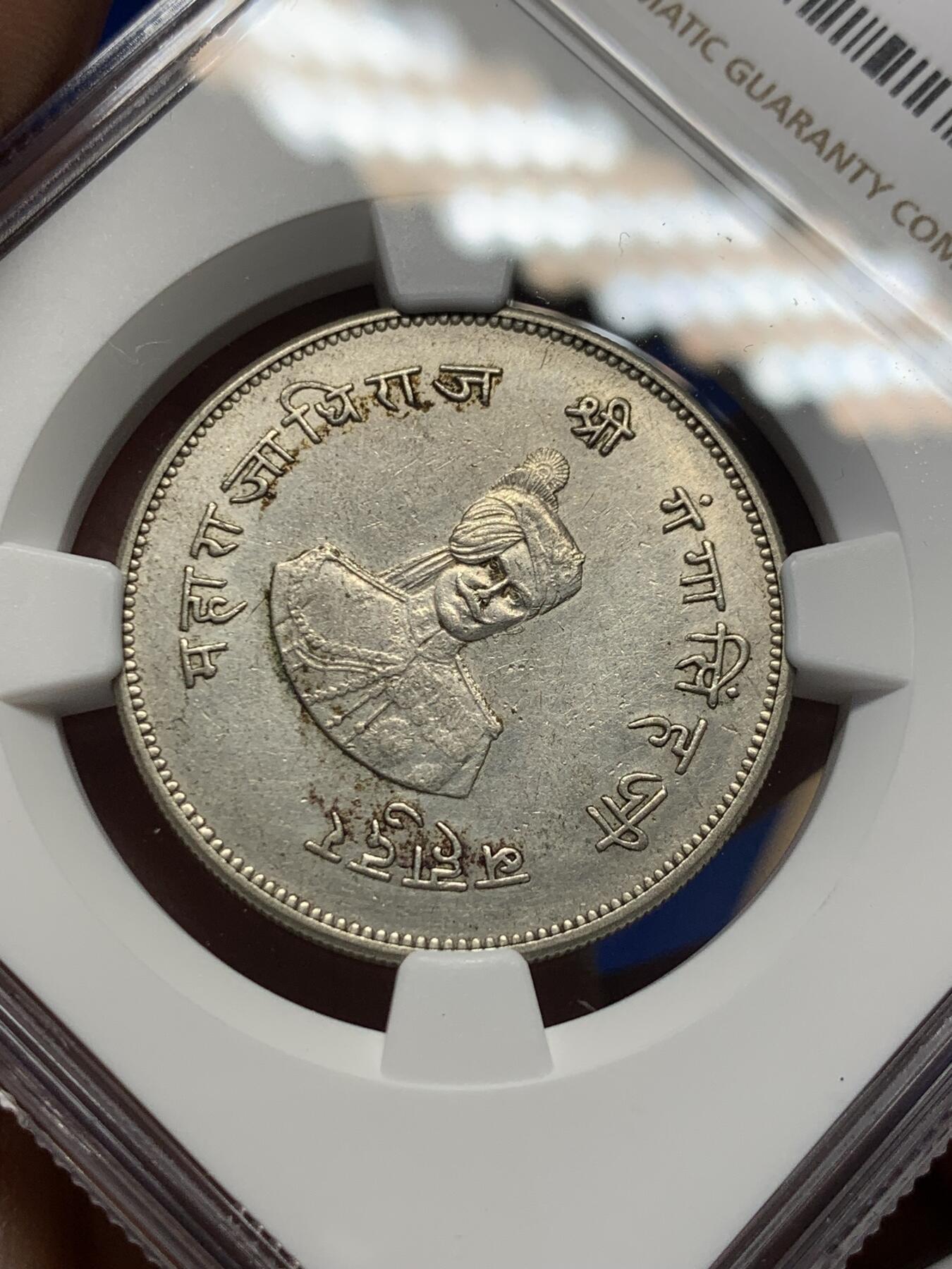 《竞宝斋》第370场 周日，周一 2场连拍 （全场包邮） NGC AU55 极少见品种 1937印度比卡内尔 玛哈拉贾冈加·辛格统治50周年 1卢比纪念银币 裸币都大几百近千的品种 好品更不多见 图案很有印度特色 正面是冈加·辛格的肖像 背面七个图案均是皇家象征