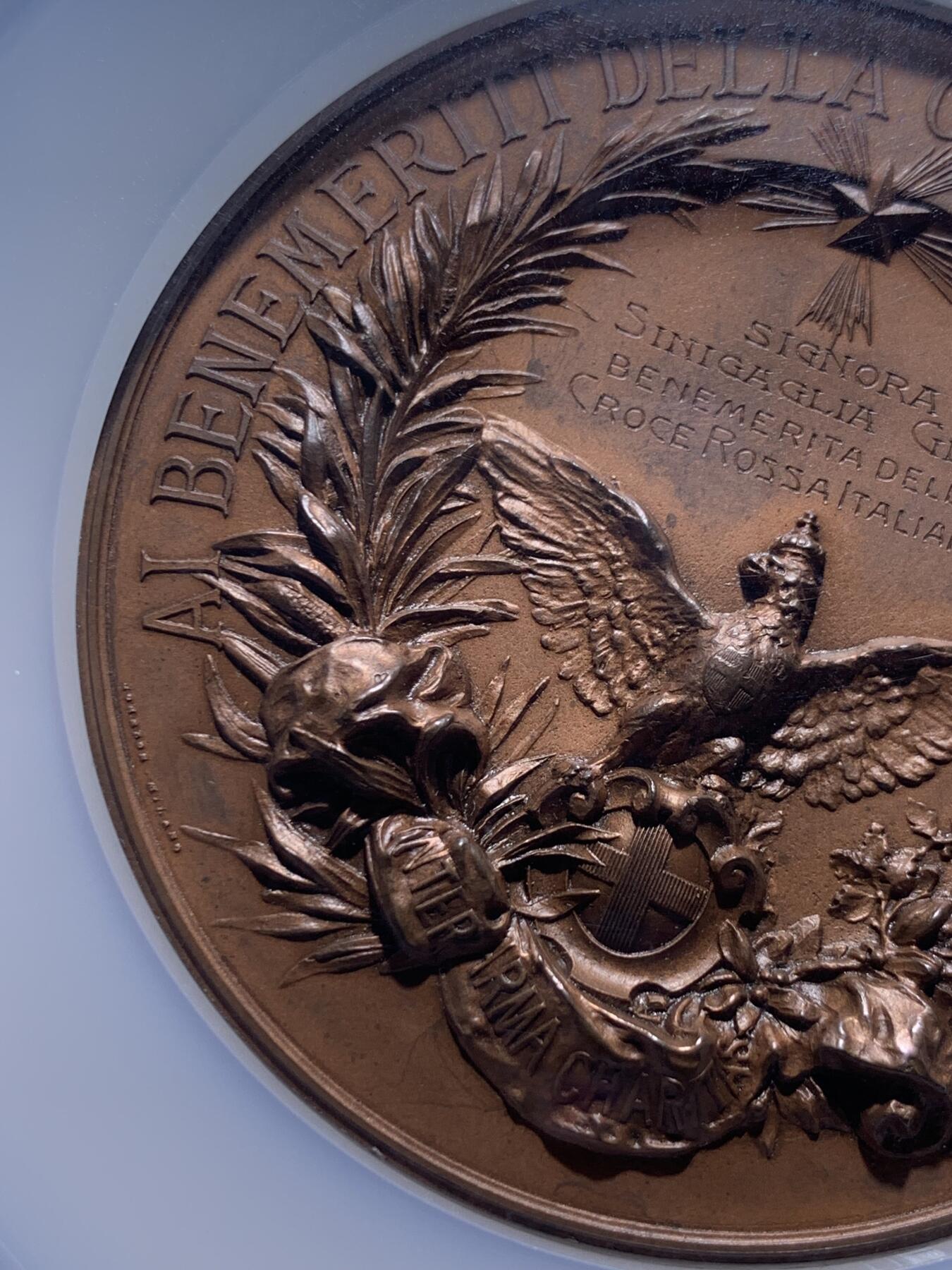 《竞宝斋》第370场 周日，周一 2场连拍 （全场包邮） NGC MS64BN 意大利红十字会纪念铜章 雕刻大师Cappuccio作品（代表作哥伦布发现新大陆铜章），直径68mm，该奖章用颁发给对意大利红十字会做出巨大贡献的人士，数量稀少。双面写实的超高浮雕，体现了掌上雕塑的魅力，且玩且珍惜。加大加厚盒