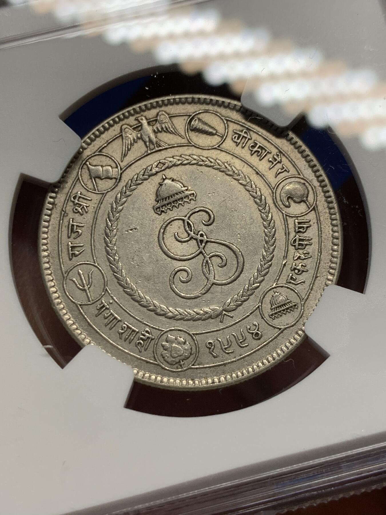 《竞宝斋》第370场 周日，周一 2场连拍 （全场包邮） NGC AU55 极少见品种 1937印度比卡内尔 玛哈拉贾冈加·辛格统治50周年 1卢比纪念银币 裸币都大几百近千的品种 好品更不多见 图案很有印度特色 正面是冈加·辛格的肖像 背面七个图案均是皇家象征