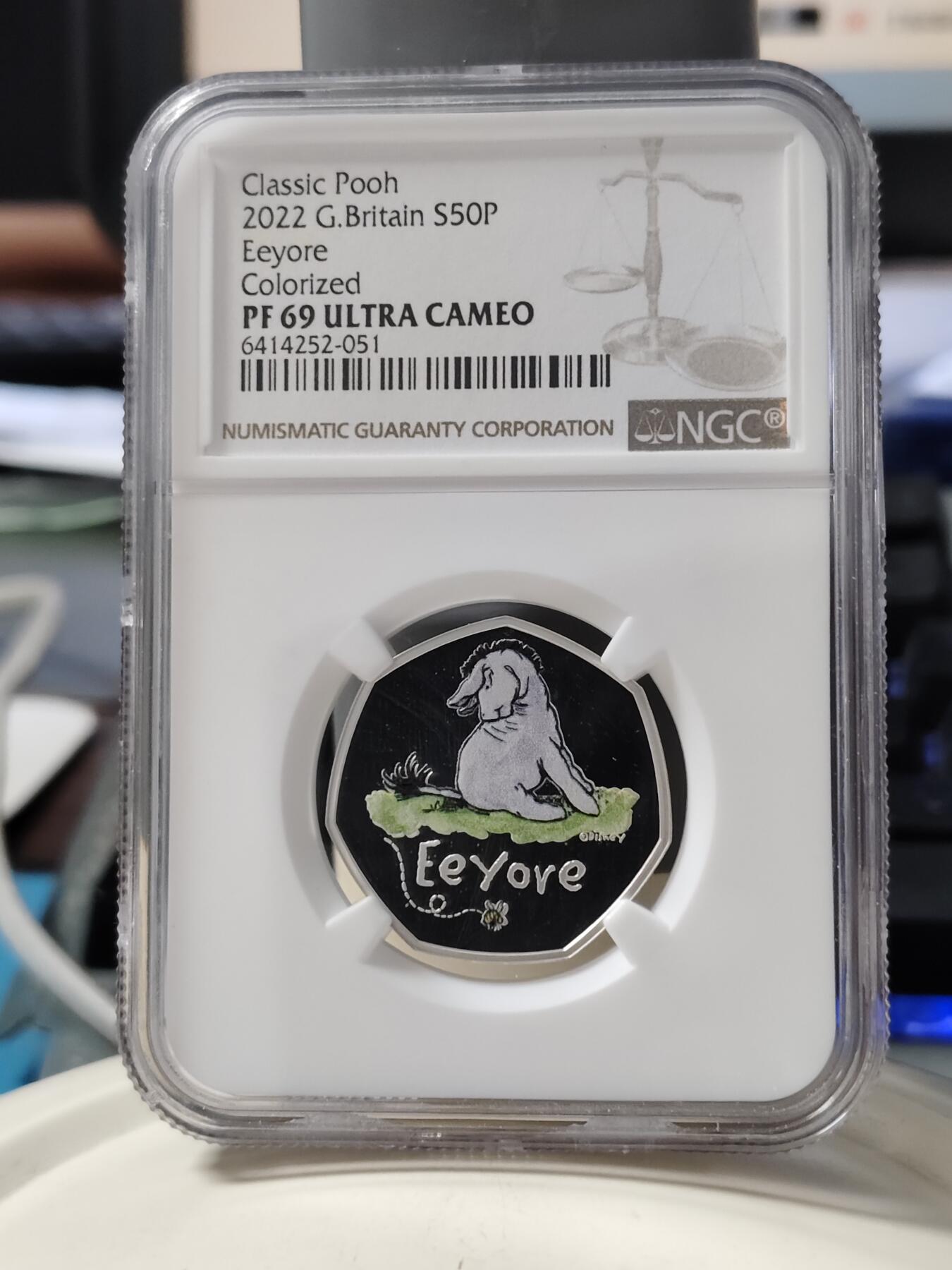 第168期拍卖【长期征集拍品】 英国2022年小熊维尼熊系列小熊屹耳精制彩色纪念银币NGC-PF69原盒证书，925银，8克，发行6000枚