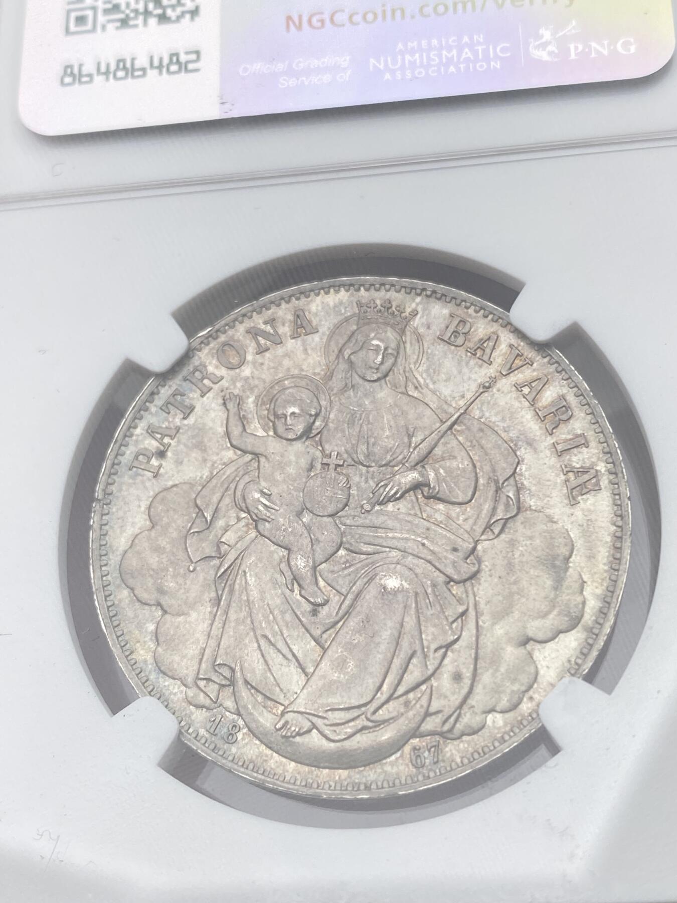 万国钱币拍卖第045期（万国春季大拍） NGC MS65 1867年德国巴伐利亚路德维希二世圣母抱婴流通1泰勒 顶级欧洲原味五彩 青灰色包浆也遮掩不住底板迸发出的原始光芒 顶级收藏品质